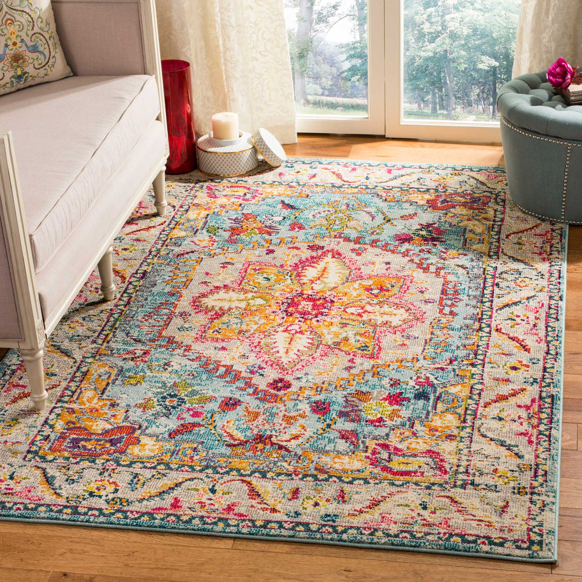 A turquoise and beige rug adds vivid floral color beneath a sofa and ottoman.
