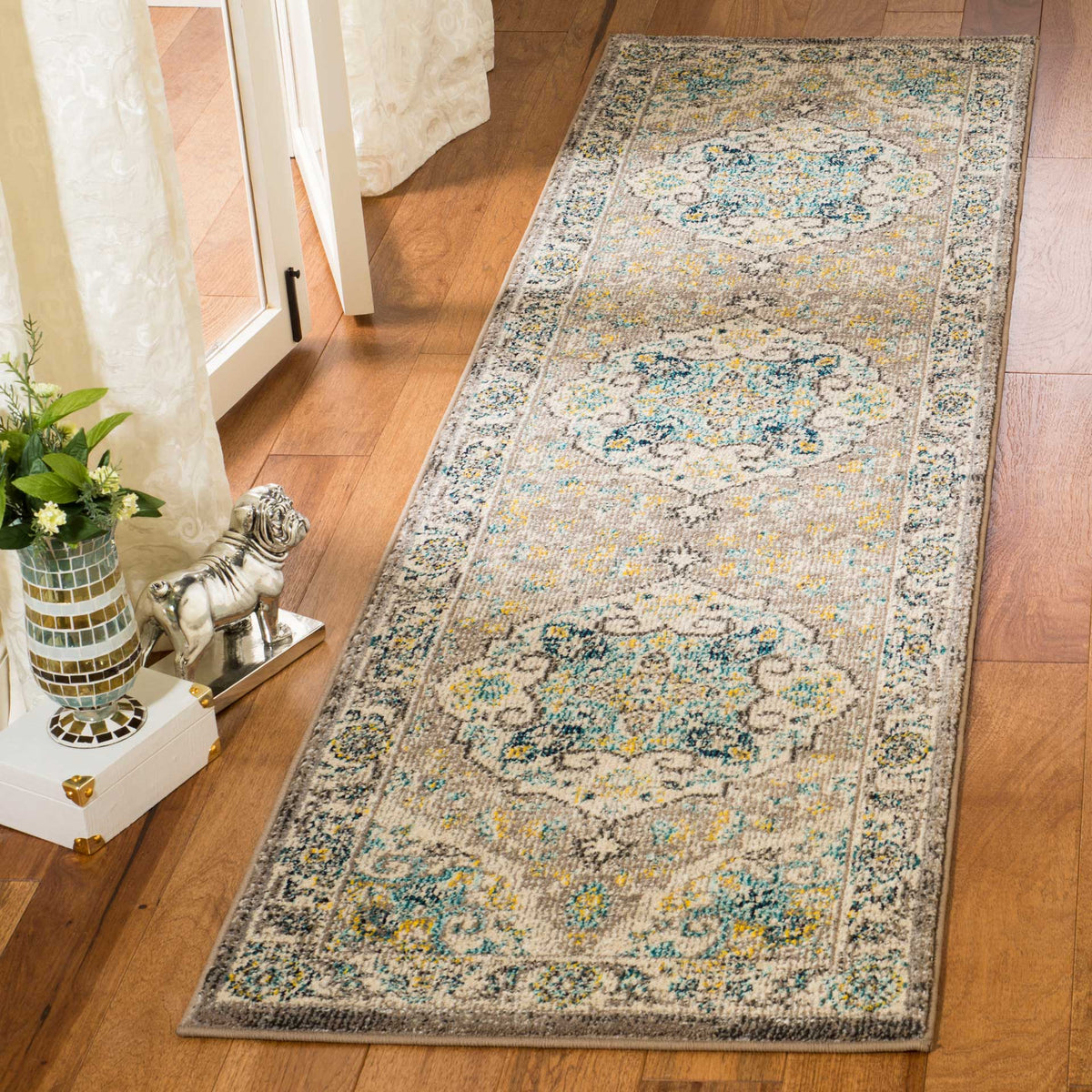 Subtle gray and ivory hues frame intricate floral medallions on this elegant hallway runner