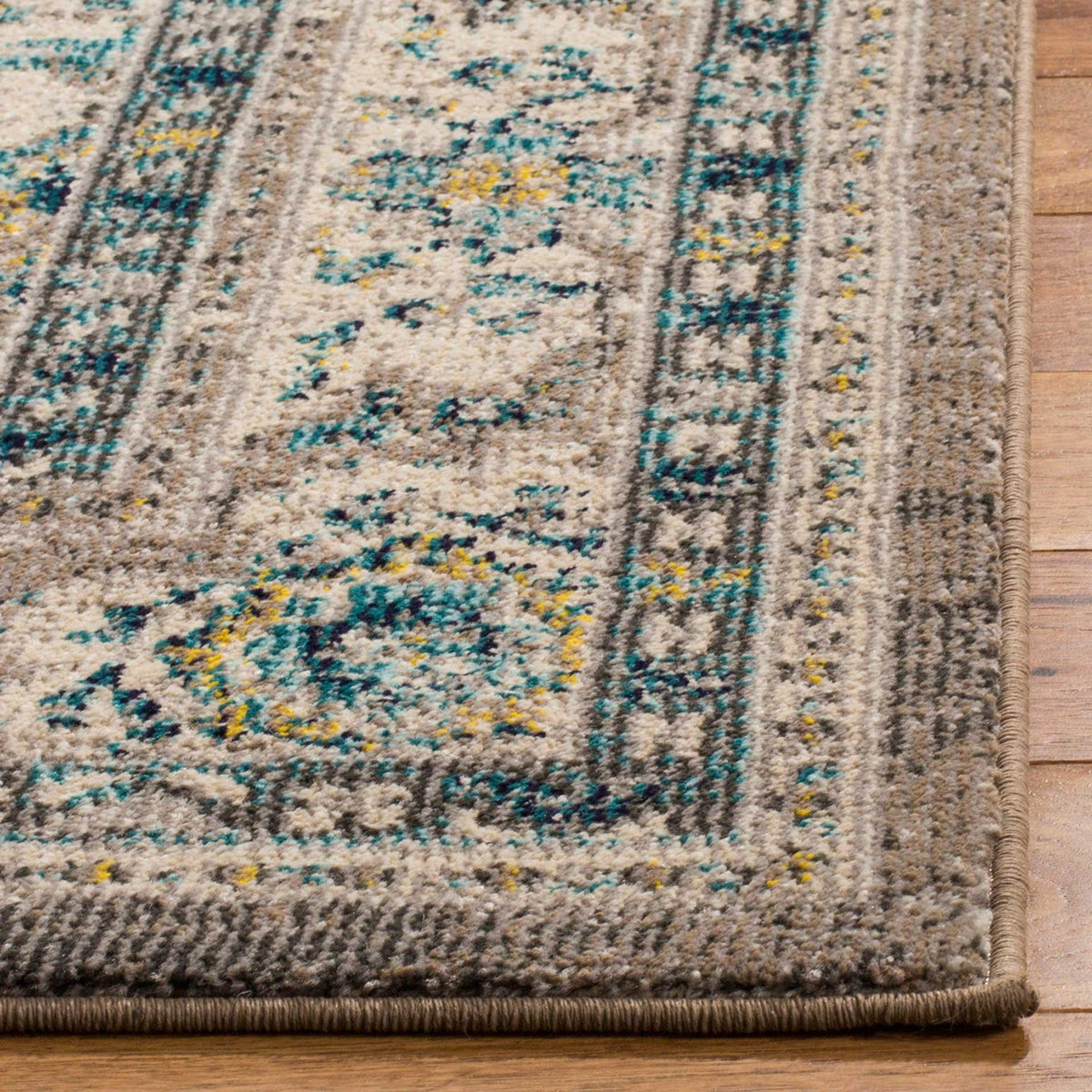 A neatly bound gray edge finishes the intricate teal, ivory, and yellow border