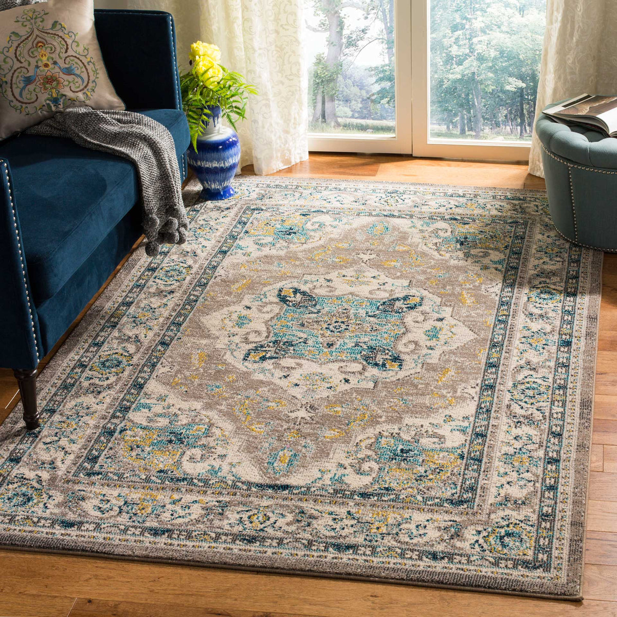 A softly distressed gray rug adds an ivory medallion and teal floral details to the seating area