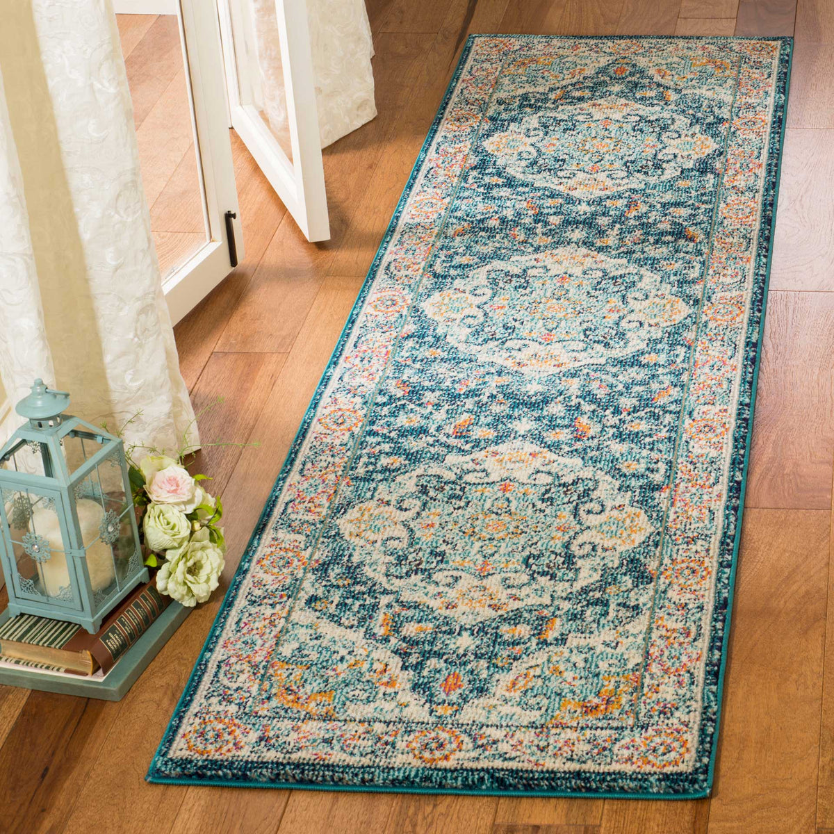 An ivory and blue runner with floral medallions and warm accents brightens a wood-floor entryway