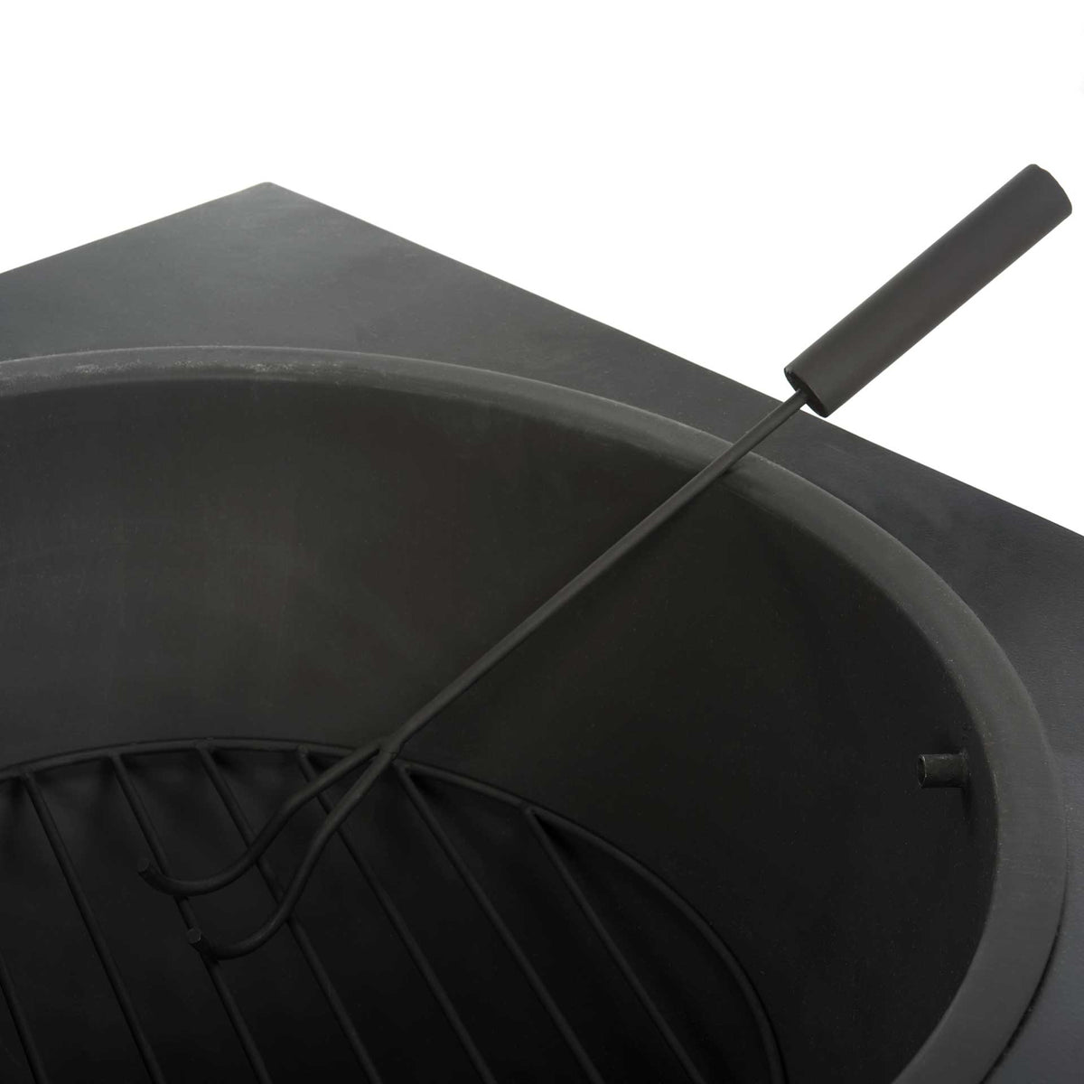 A long-handled fire poker rests above the metal grate inside the deep black fire bowl.