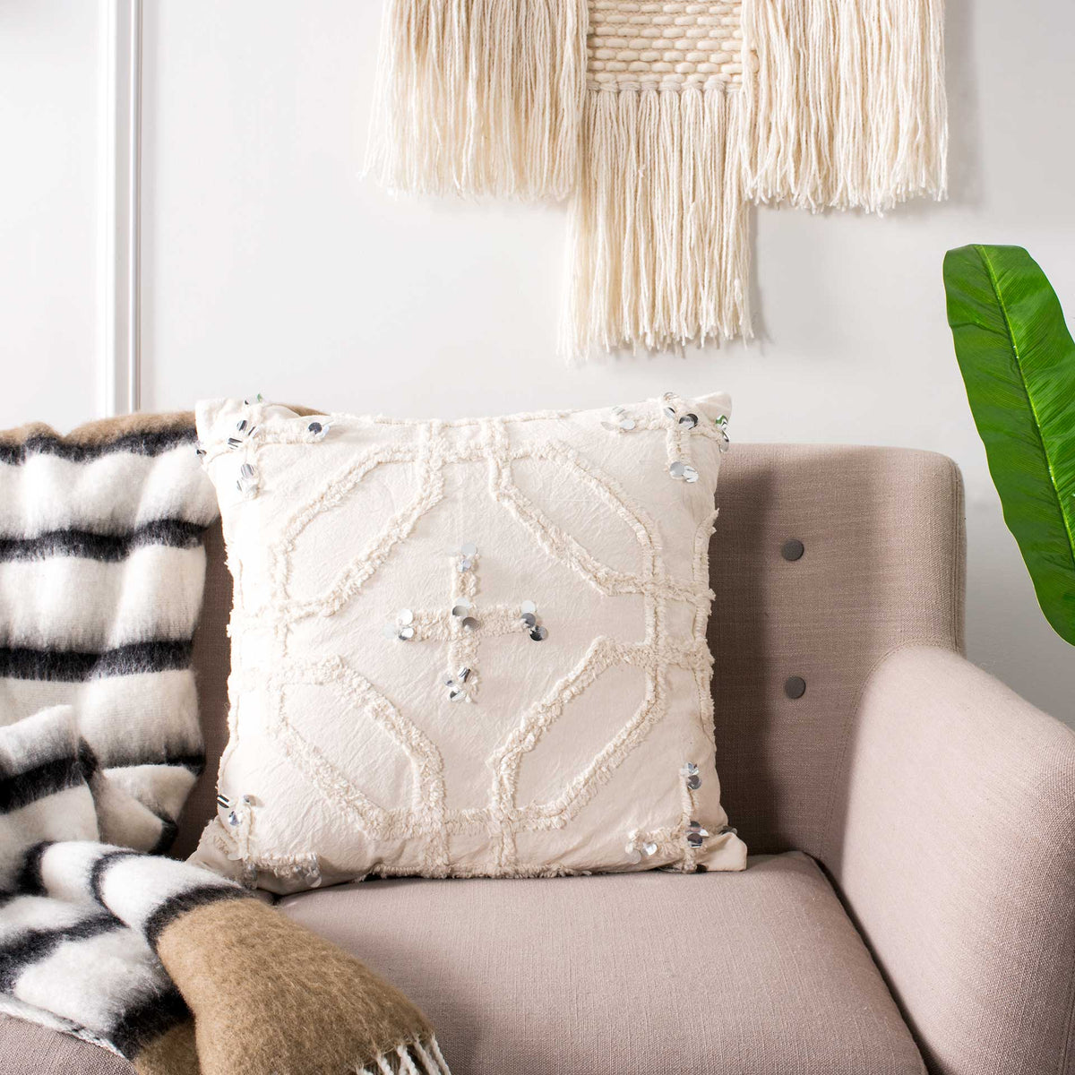 White accent pillow with plush geometric tufting and glinting sequins adds texture to a sofa