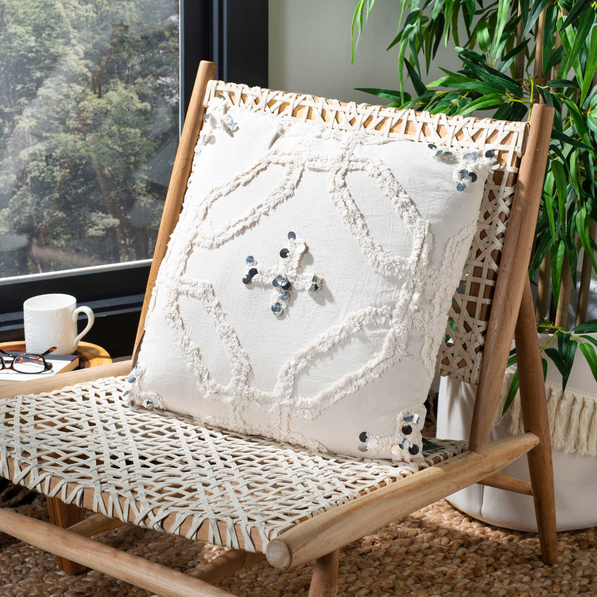 Raised ivory tufting and sparkling sequin accents enrich a white pillow on a woven chair