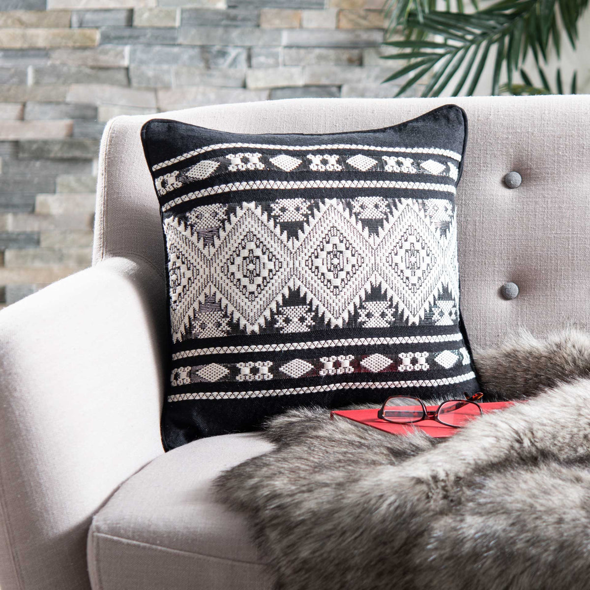 Black-and-ivory geometric pillow adds bold contrast to a neutral chair