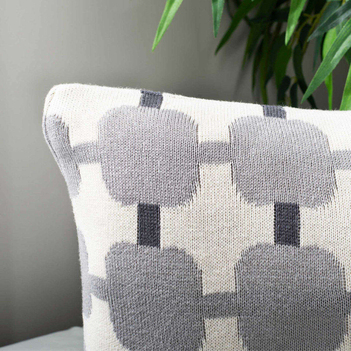 Textured woven fibers give light gray shapes and charcoal bars depth on this soft lumbar pillow