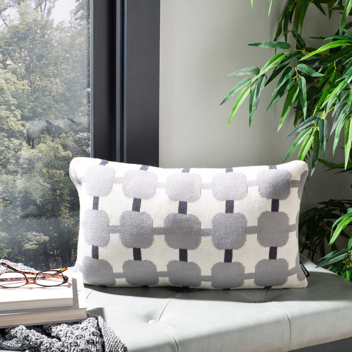 An ivory lumbar pillow adds soft woven texture and a rhythmic gray pattern to any seat
