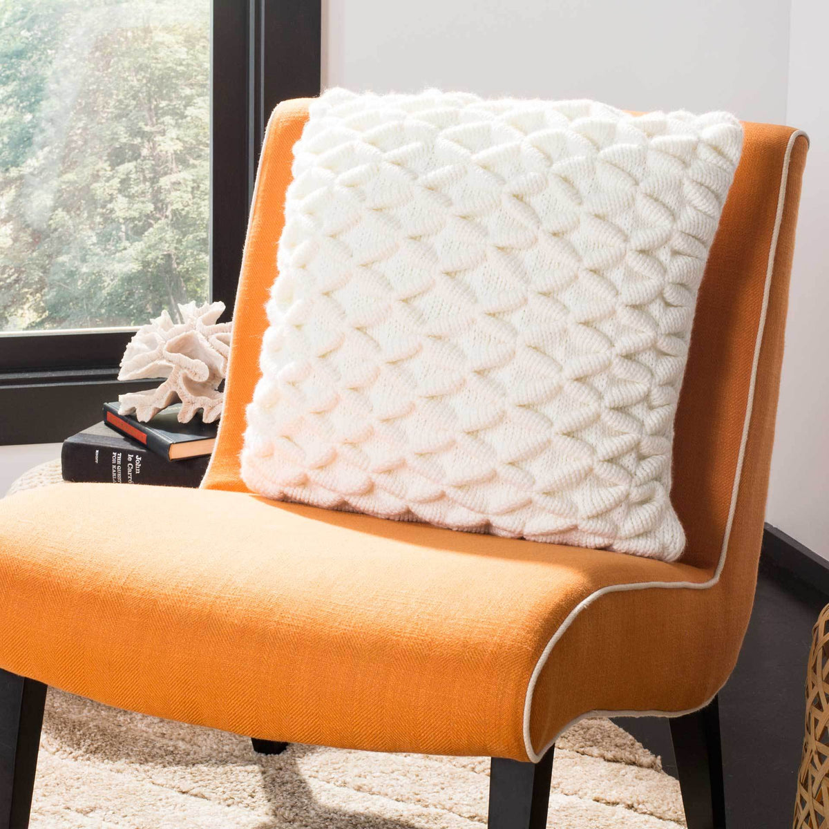 Dimensional ivory diamonds lend cozy softness to an orange accent chair