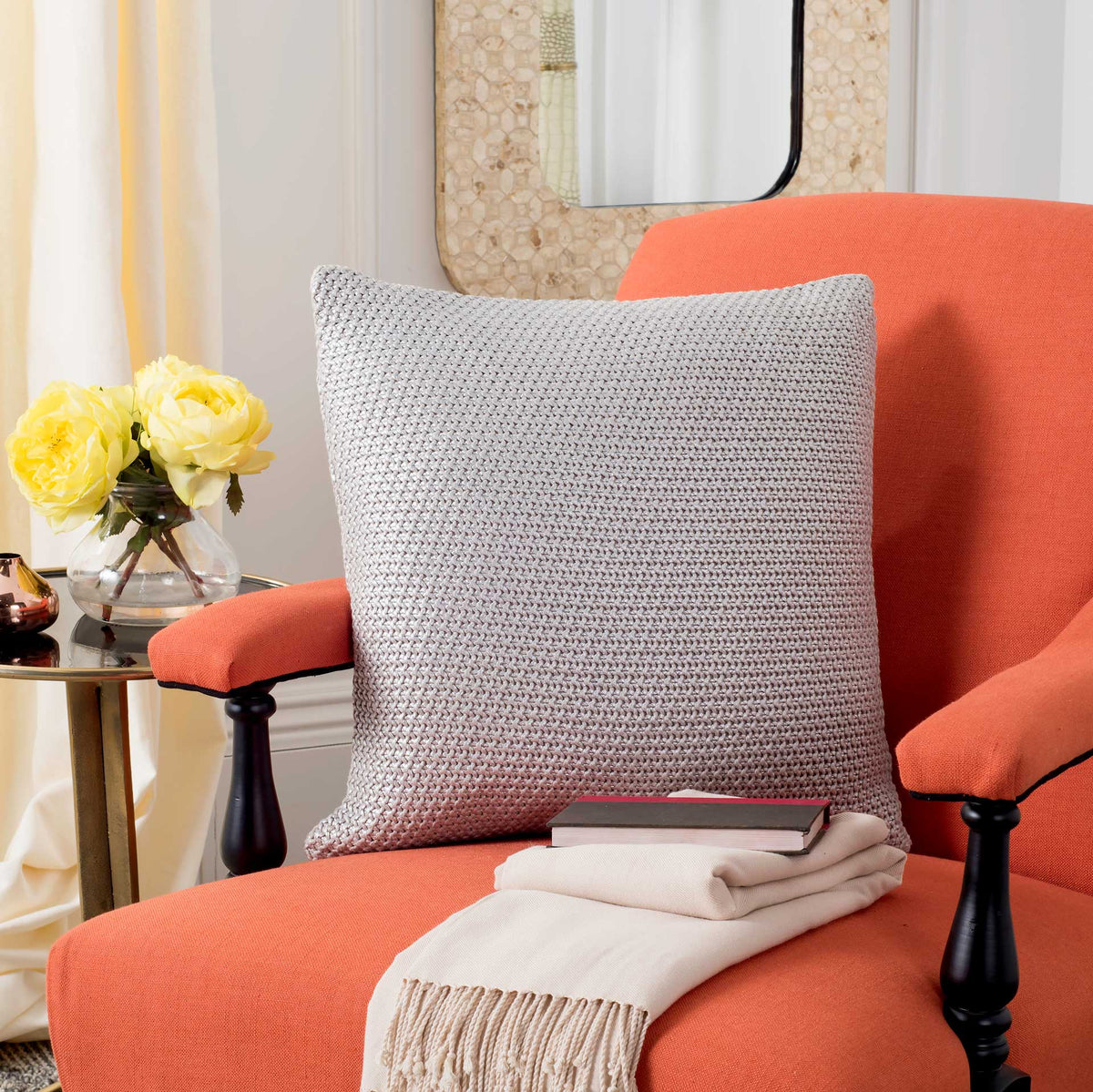 Textured gray knit pillow adds a soft, neutral accent to a coral upholstered chair