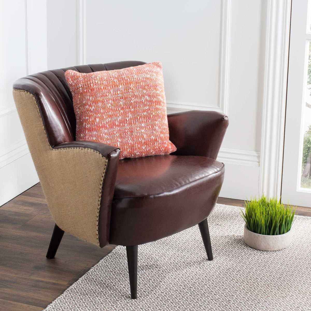 Warm terracotta and ivory hues give this textured knit pillow a cozy, inviting look