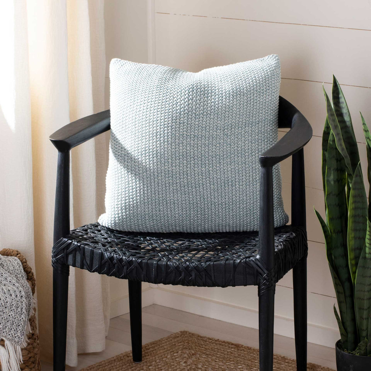 Plump pale blue knit pillow brings soft texture and comfort to a chair