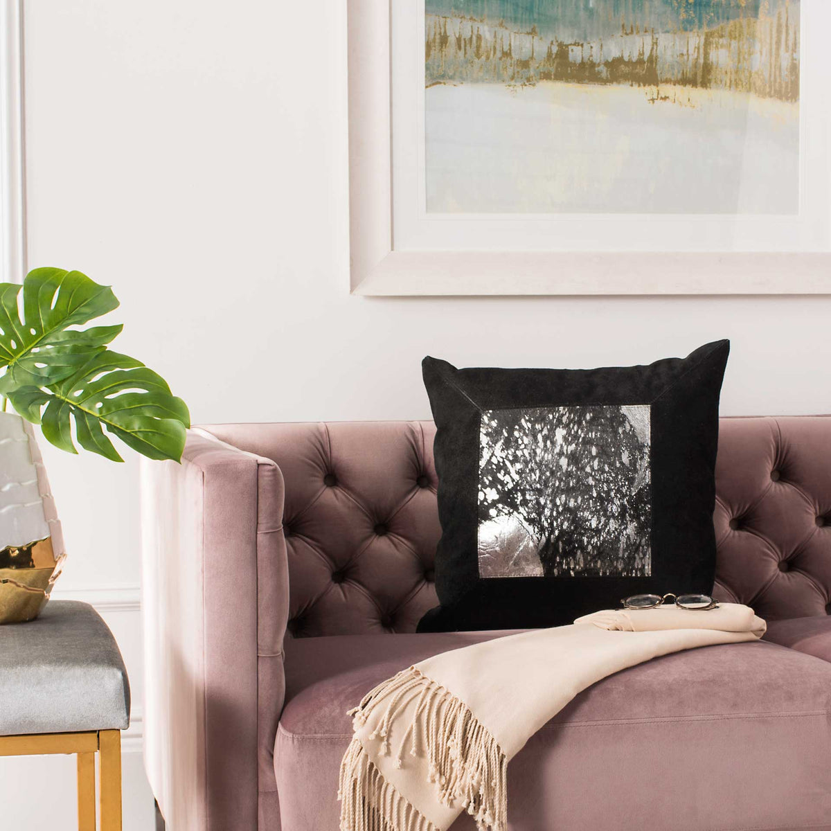 Silver-flecked black pillow adds a bold metallic accent to a tufted mauve sofa.