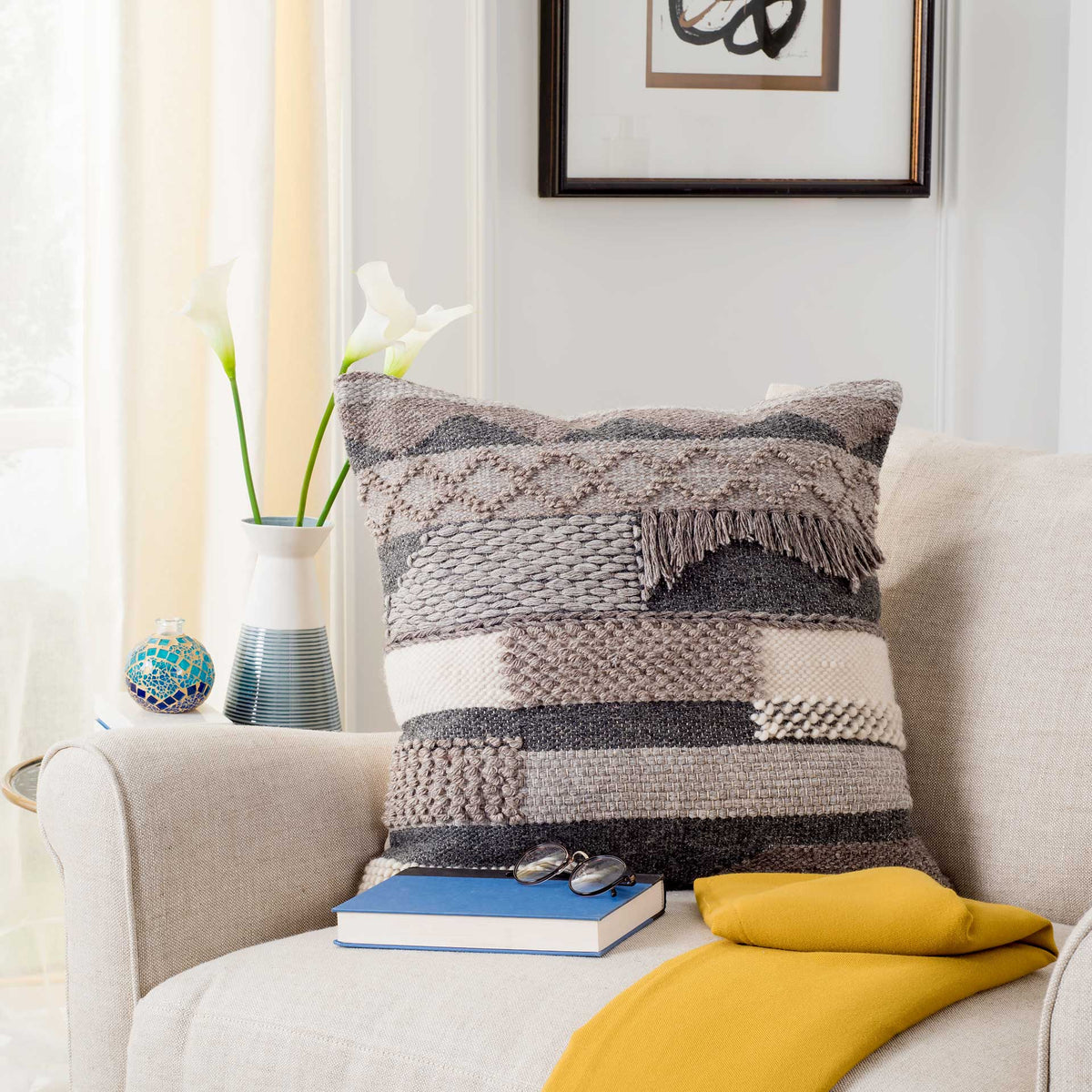 Layered charcoal, cream and taupe textures complement a neutral sofa