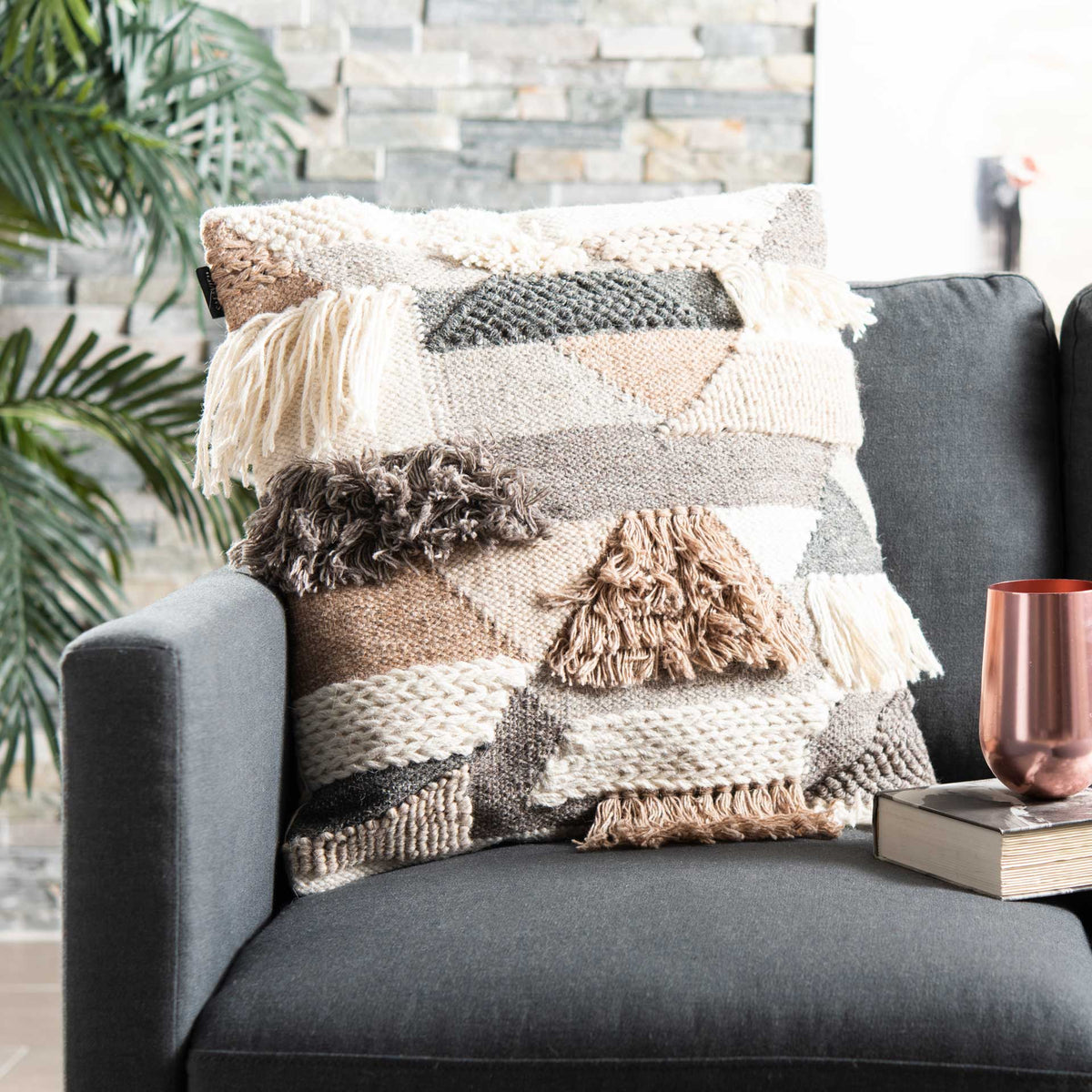 Raised woven bands and flowing tassels give this neutral pillow a warm, layered look