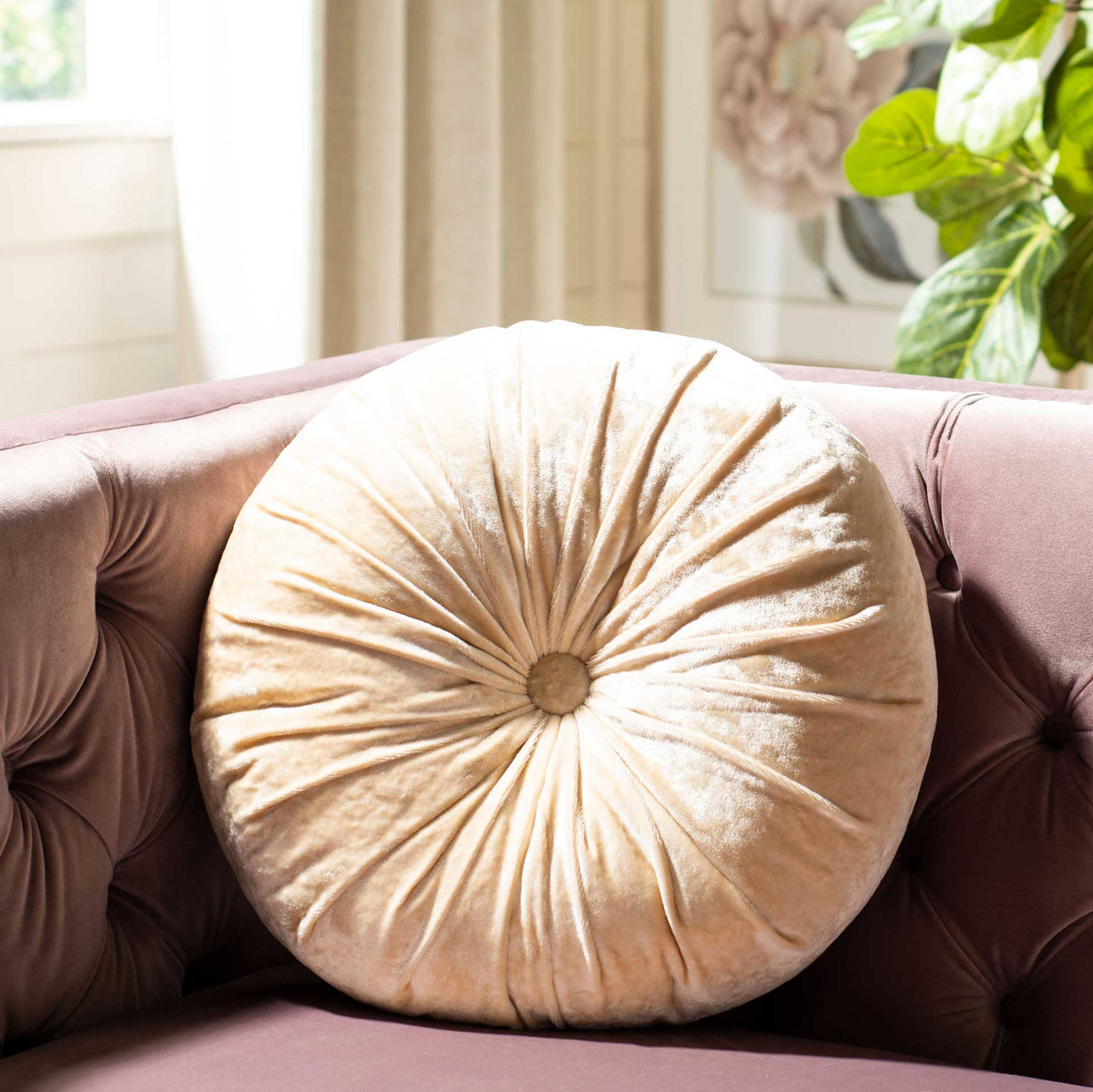 Plush round creme pillow adds sculptural, sunburst pleats to a blush sofa