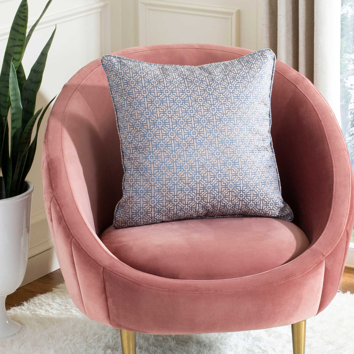 Blue and tan geometric pillow adds a cozy, patterned accent to an upholstered chair