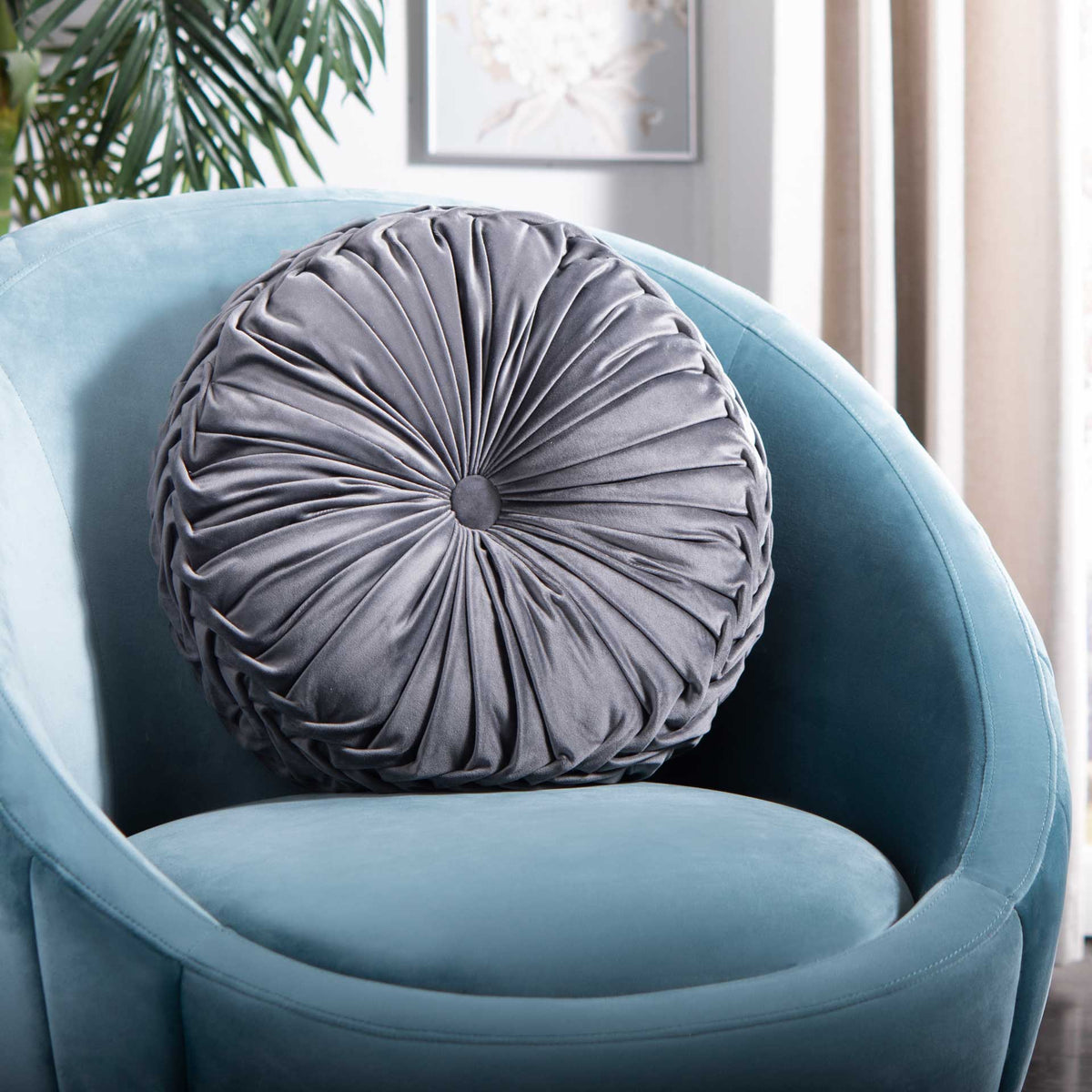 Gray round pillow adds soft sheen and gathered texture to an accent chair