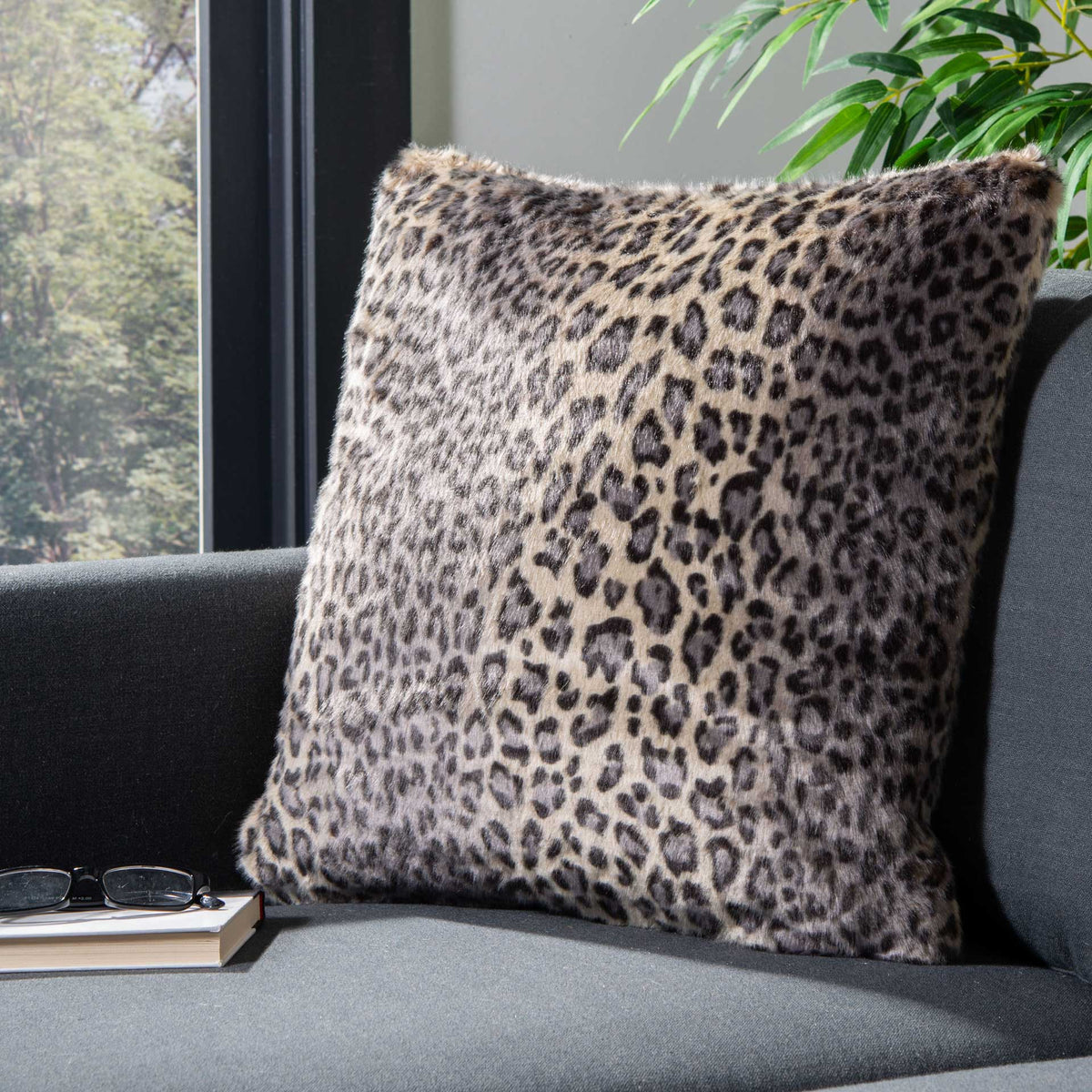 A leopard-print pillow brings cozy animal pattern to a dark sofa.