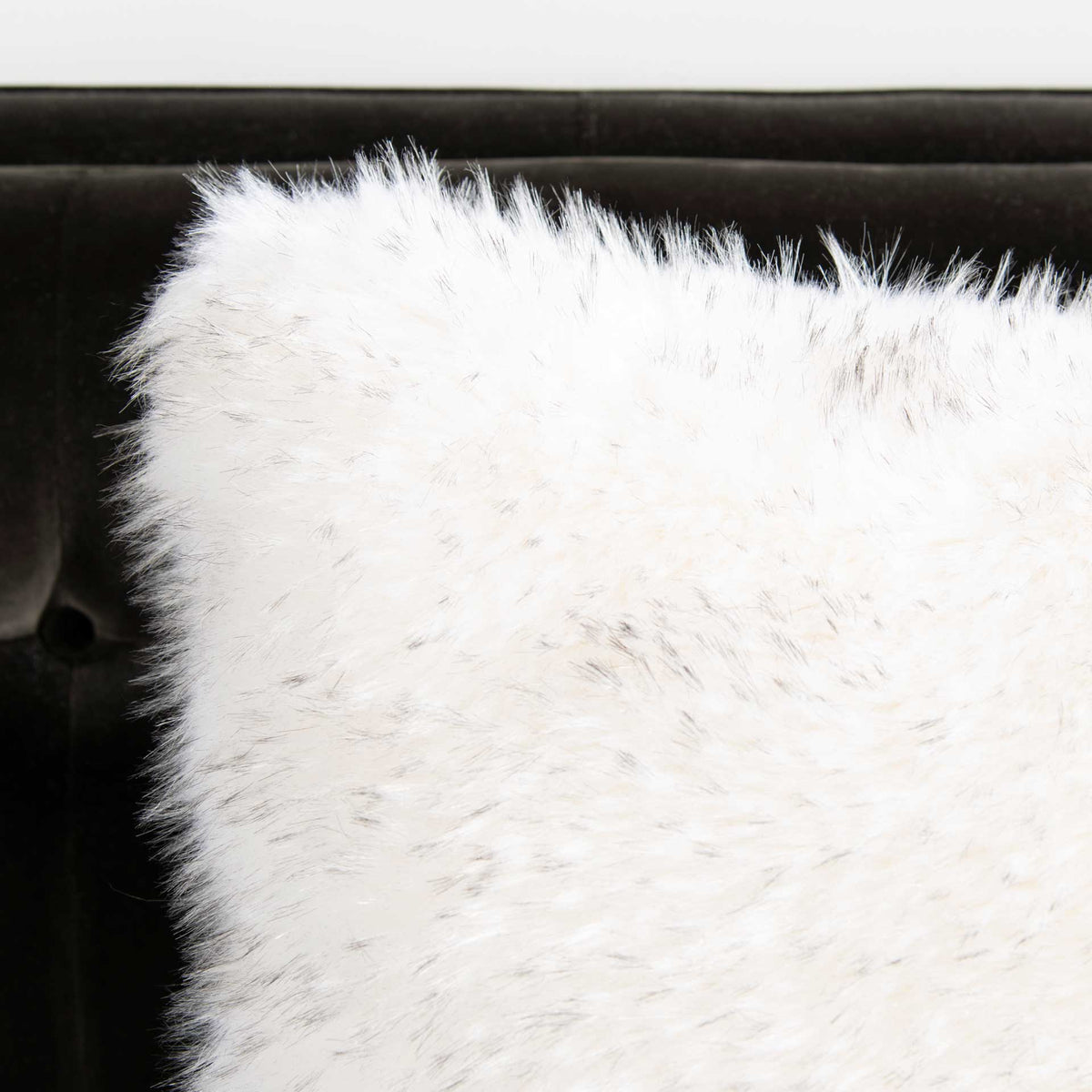 Wispy faux fur gives the cream pillow a cloudlike texture.