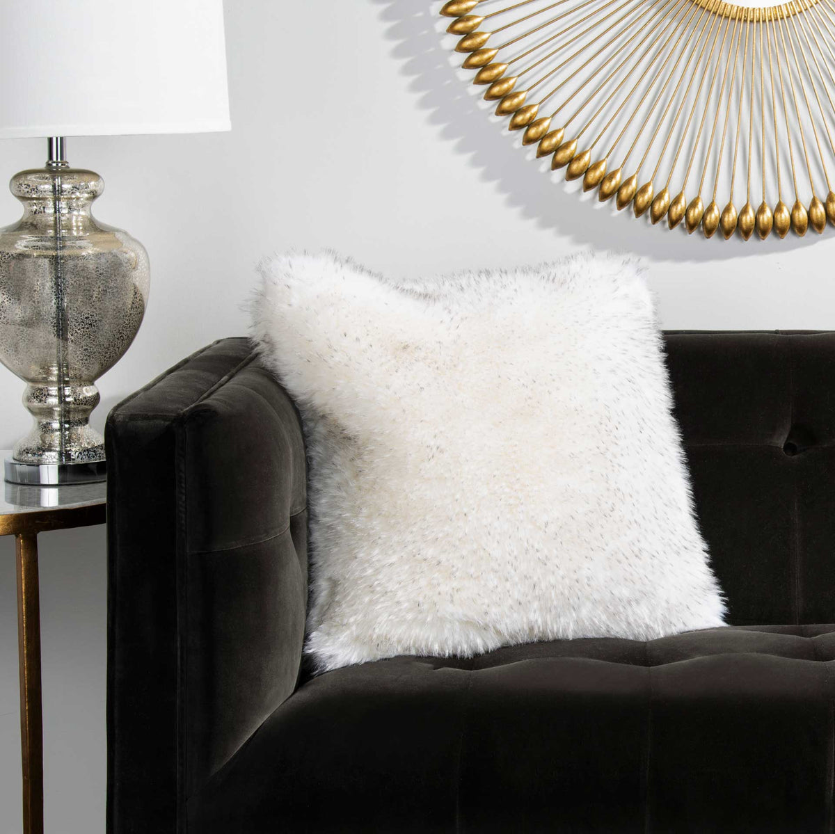 An ivory faux fur pillow softens the look of a dark upholstered sofa.