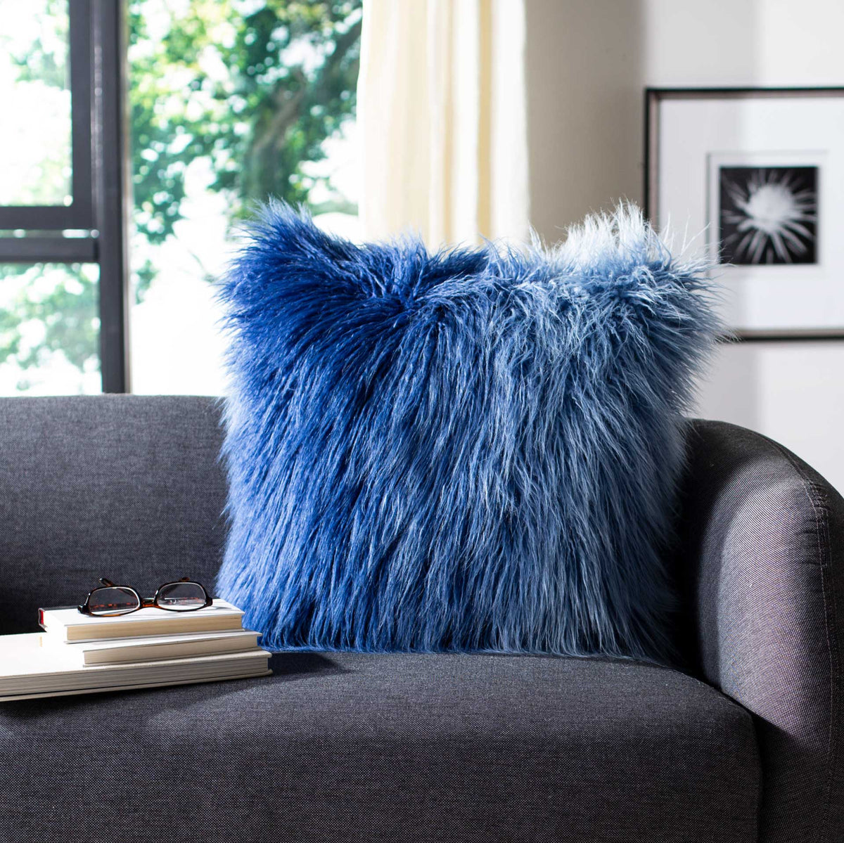 An ombre blue shag pillow adds vivid texture to a dark sofa.