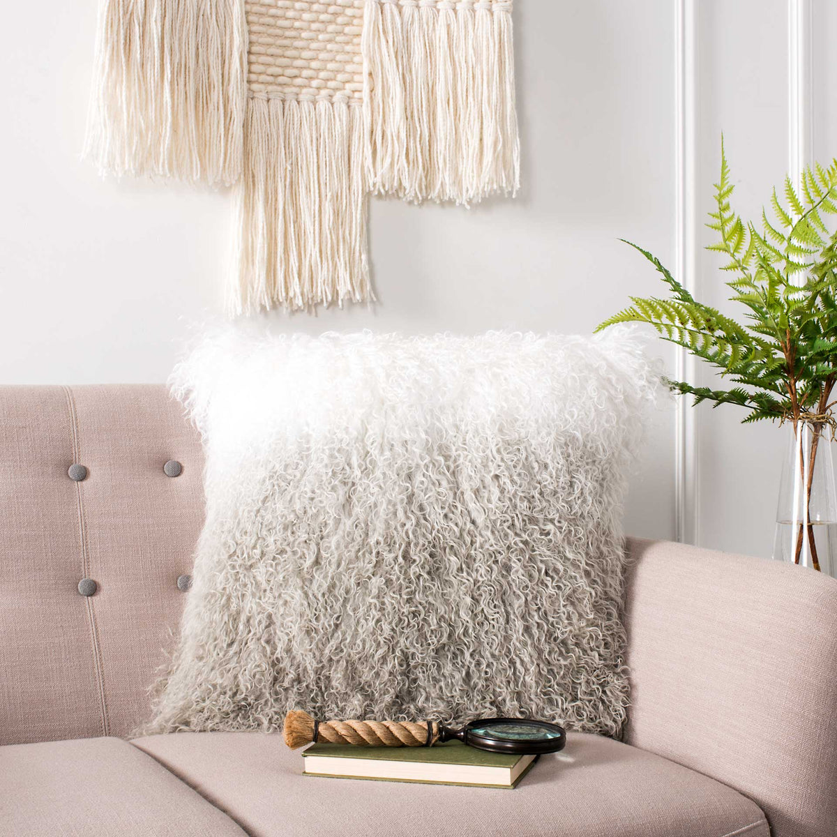 Fluffy white and gray sheepskin pillow brings cozy texture to a blush sofa