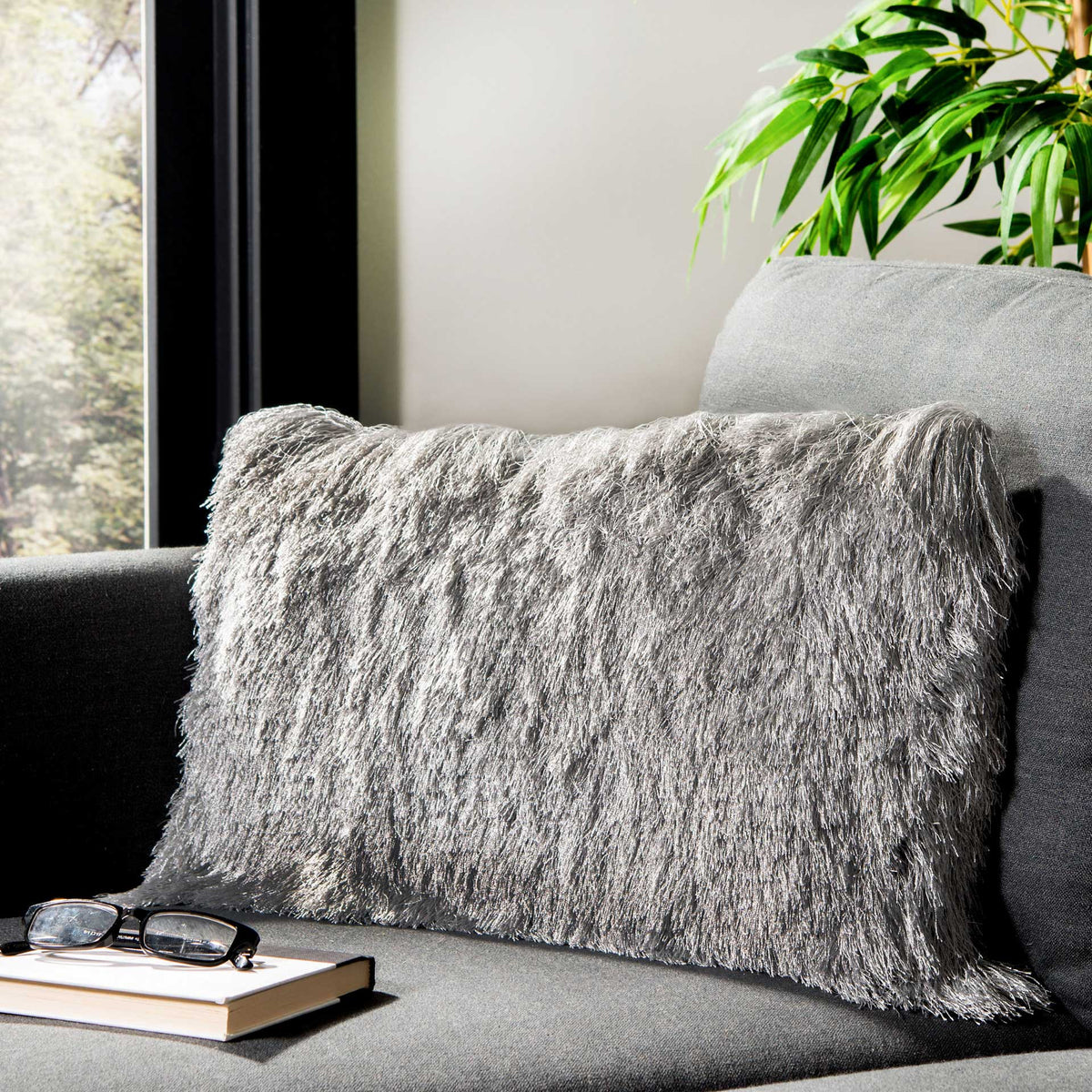 Shimmering silver shag pillow brings soft texture and modern appeal to a gray sofa