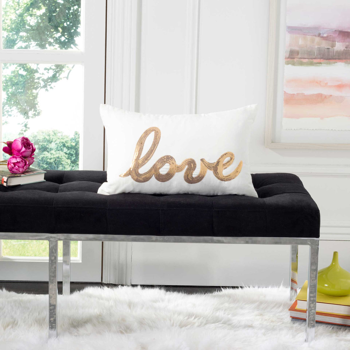 Shimmering gold 'love' script adds warmth to this cream pillow on a modern bench