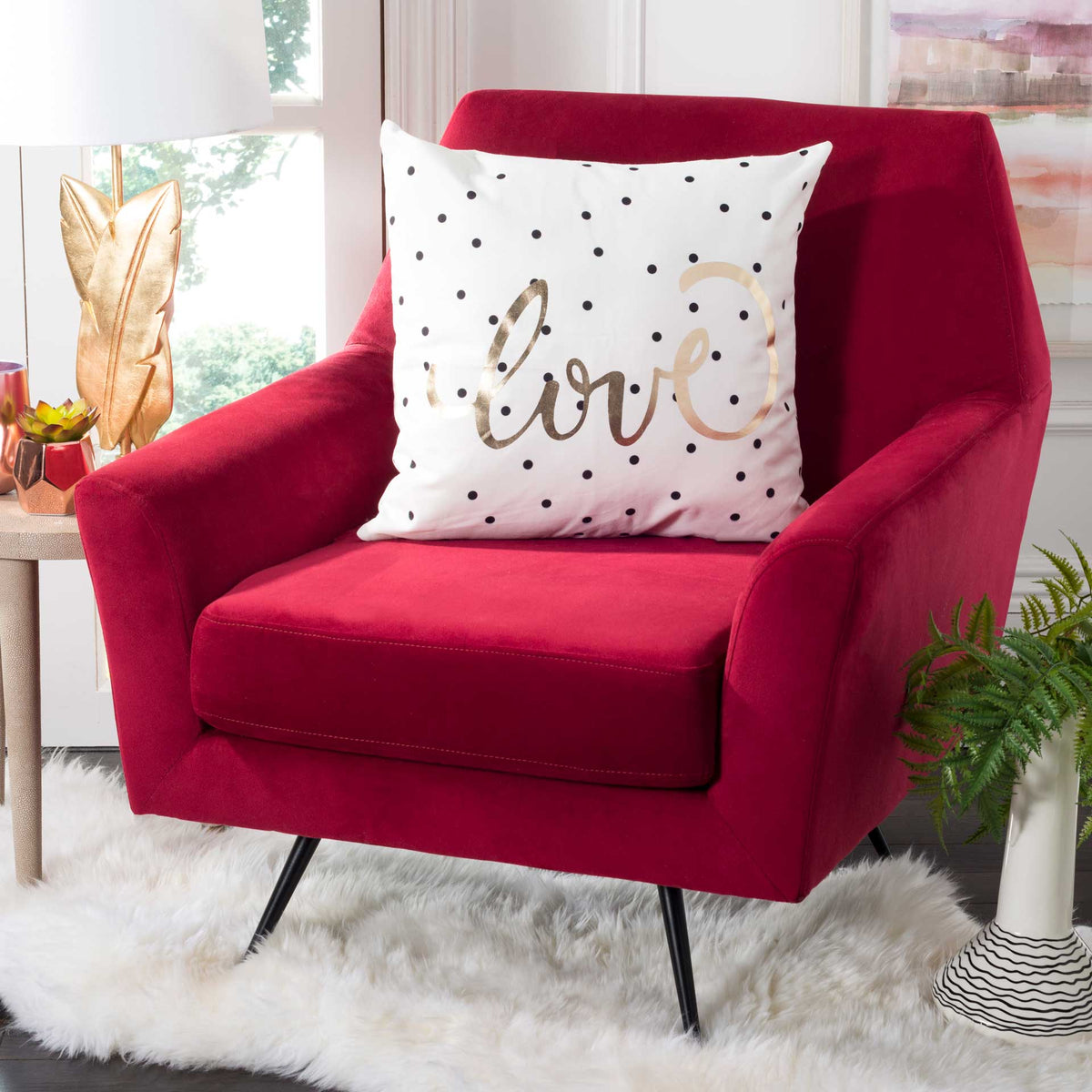 Black dots and gold love lettering give this white pillow a playful accent for a favorite seat