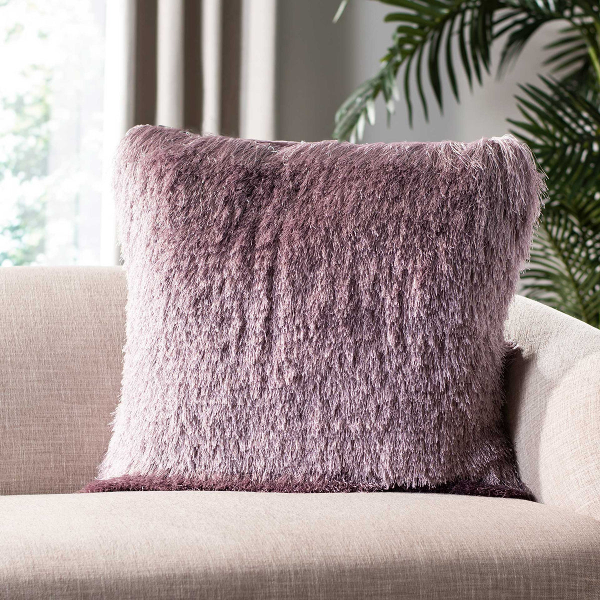 Plush lilac shag brings inviting texture to this square pillow on a neutral sofa.