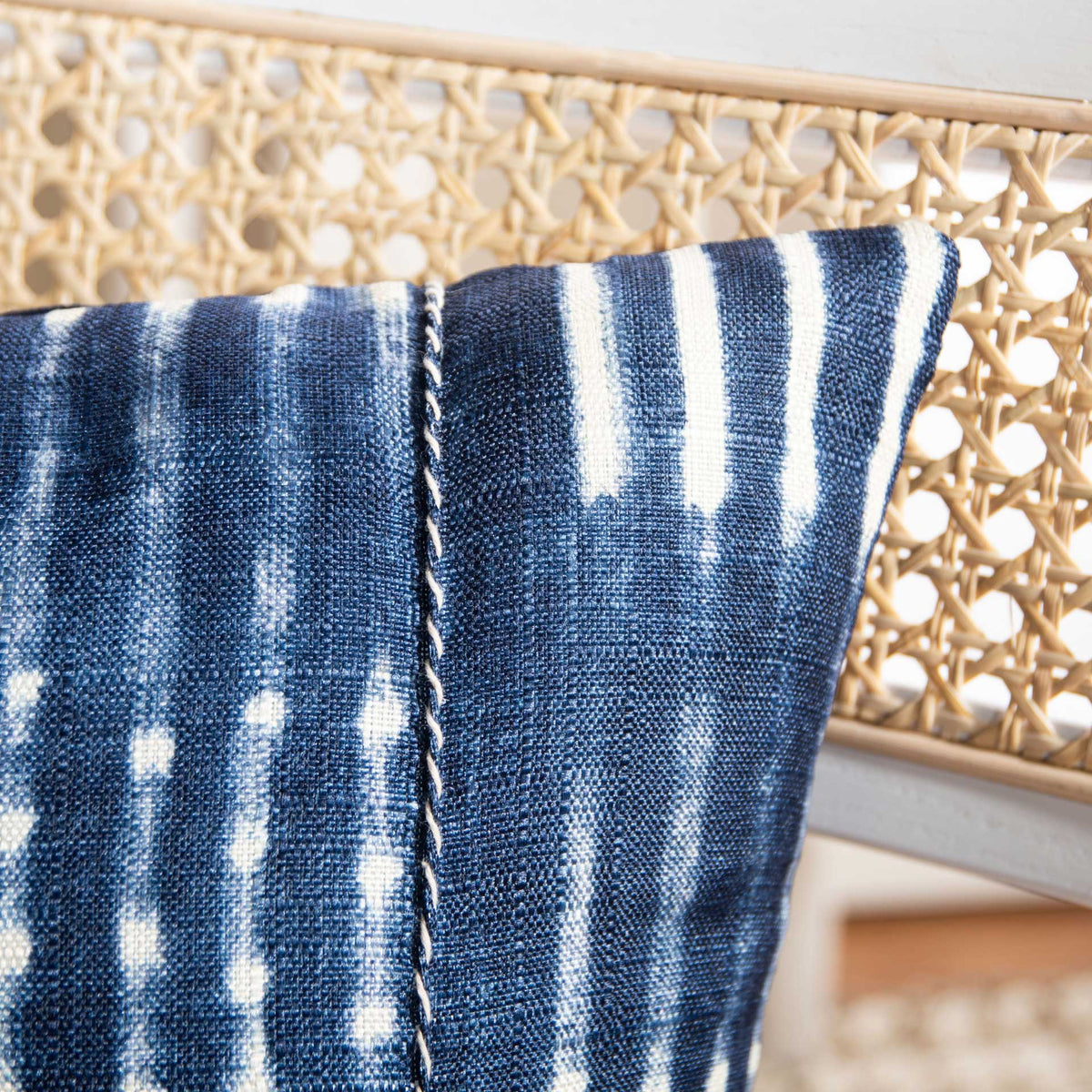 Textured navy fabric shows cream stripes and a decorative stitched seam