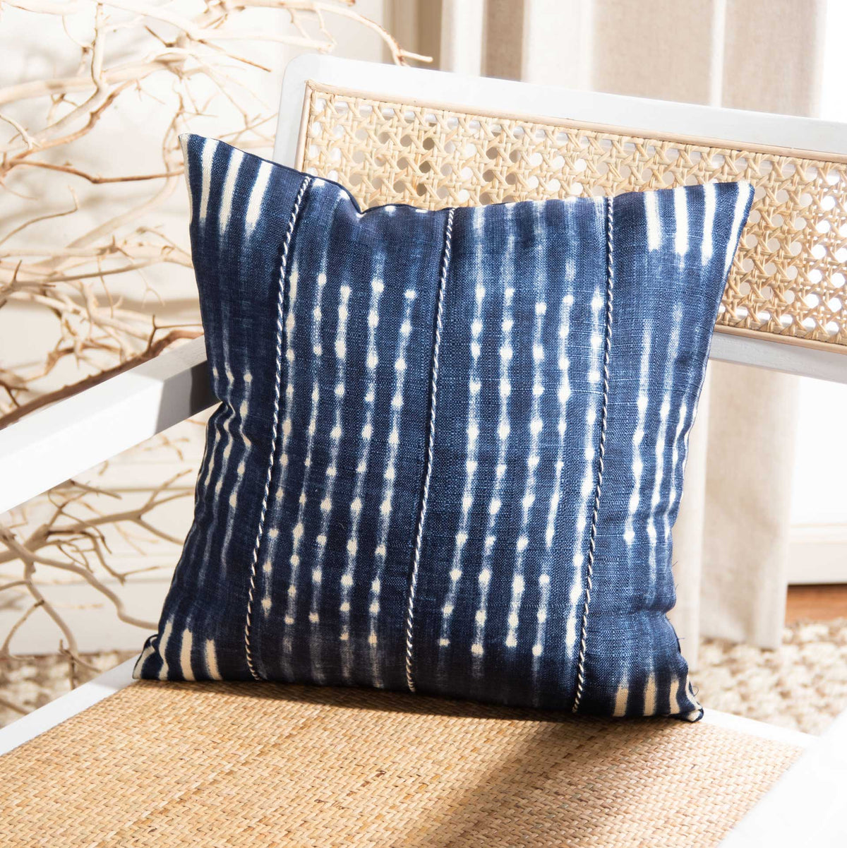 Navy and cream striped pillow adds contrast to a woven accent chair
