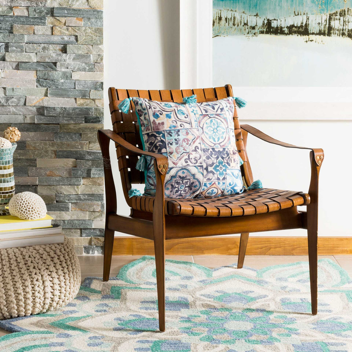 A patterned accent pillow brings tile-inspired color and teal tassels to a wood armchair.