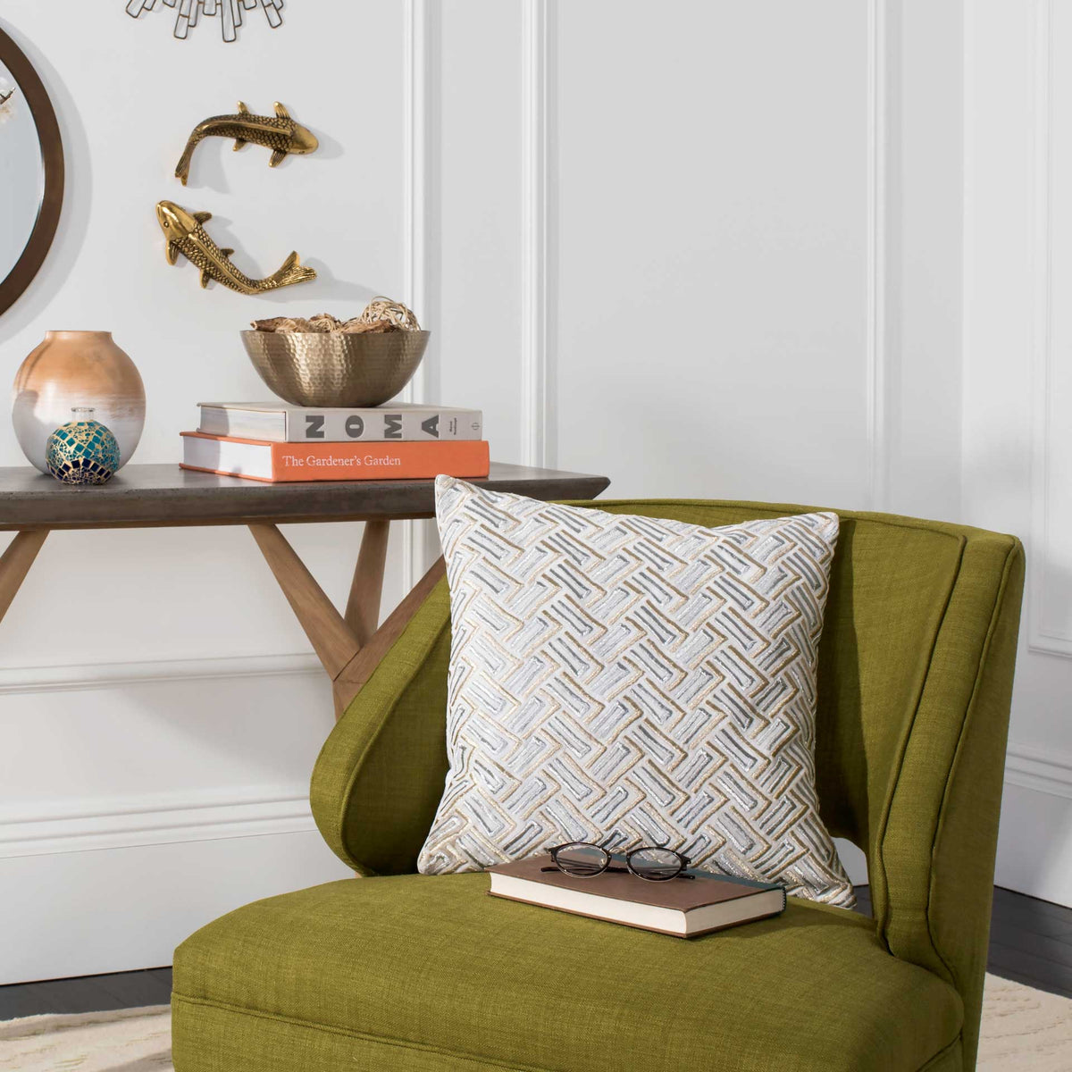 Textured gray and gold geometric pillow adds warmth to a green accent chair