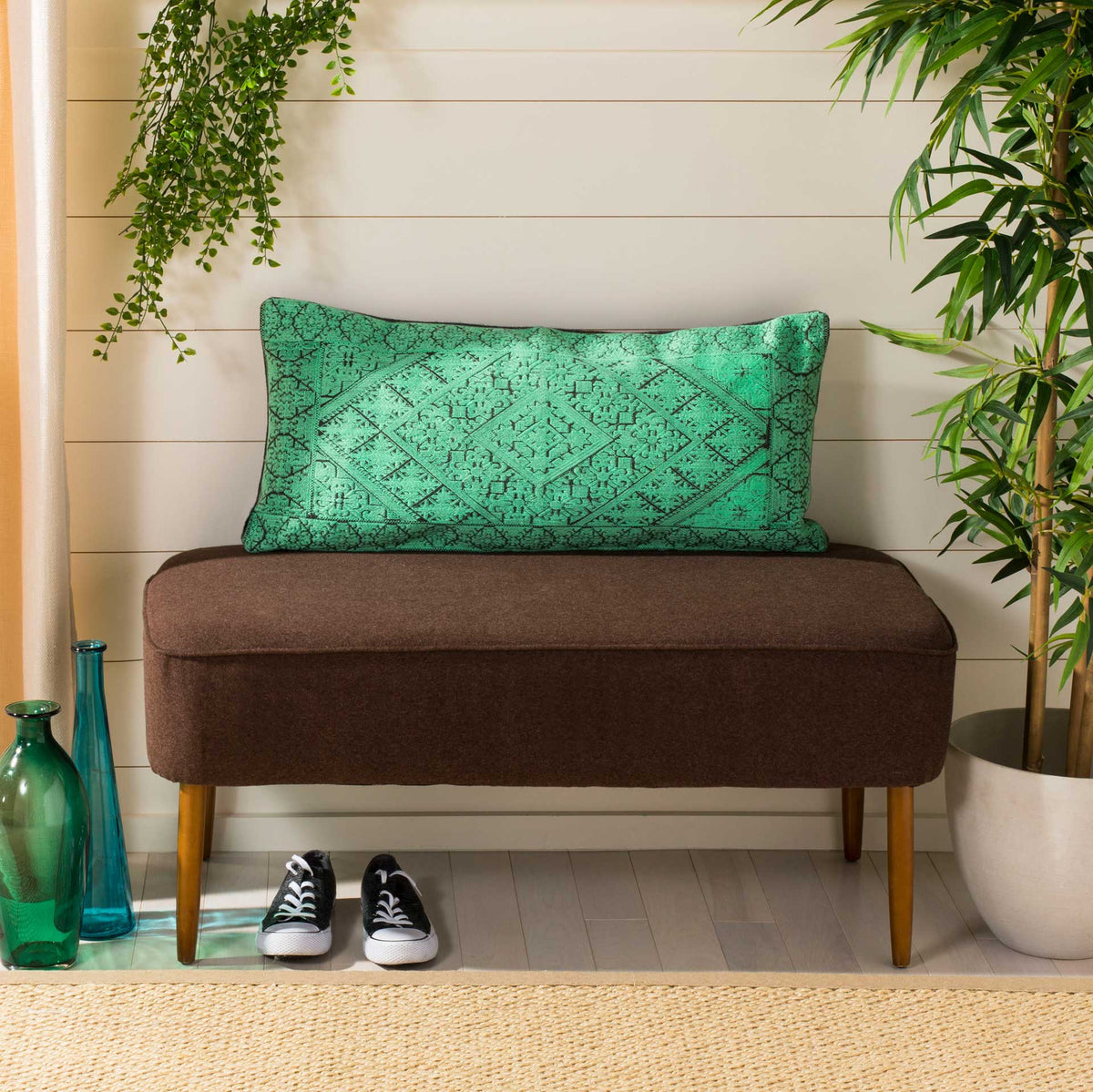 An elongated teal pillow lends intricate geometric pattern and inviting color to a bench.