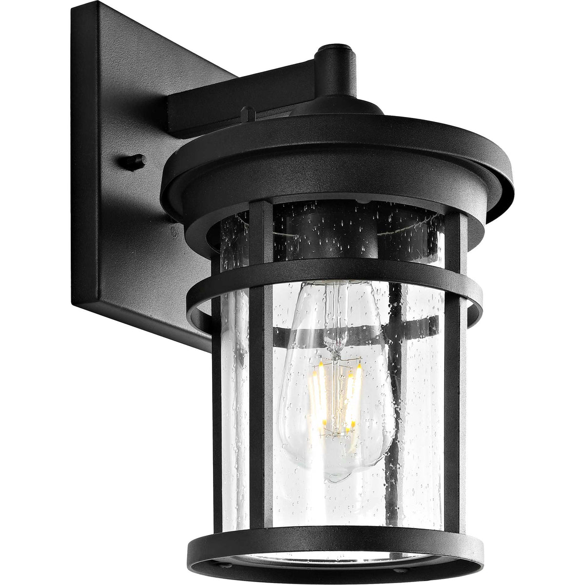 An exposed bulb glows within the clear glass and black metal frame of an outdoor wall lantern