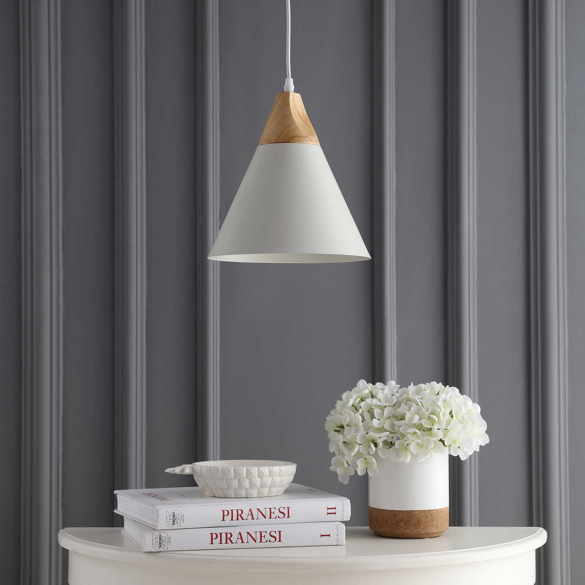 A white conical shade and natural-toned accent add clean lines over a console.