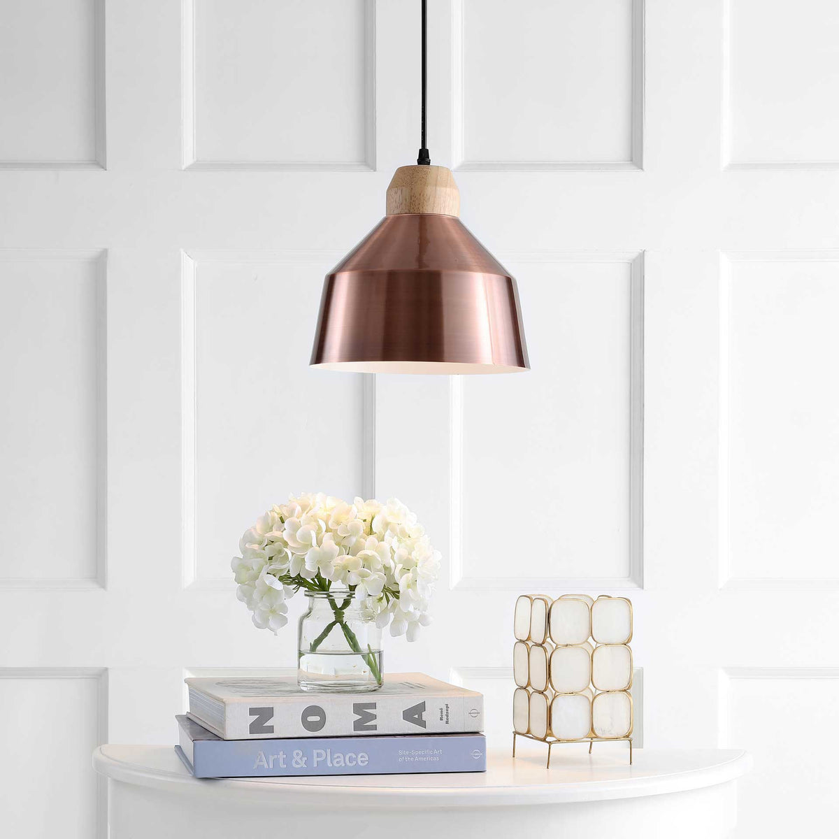 The copper pendant shines downward, lending a warm glow beneath its flared shade