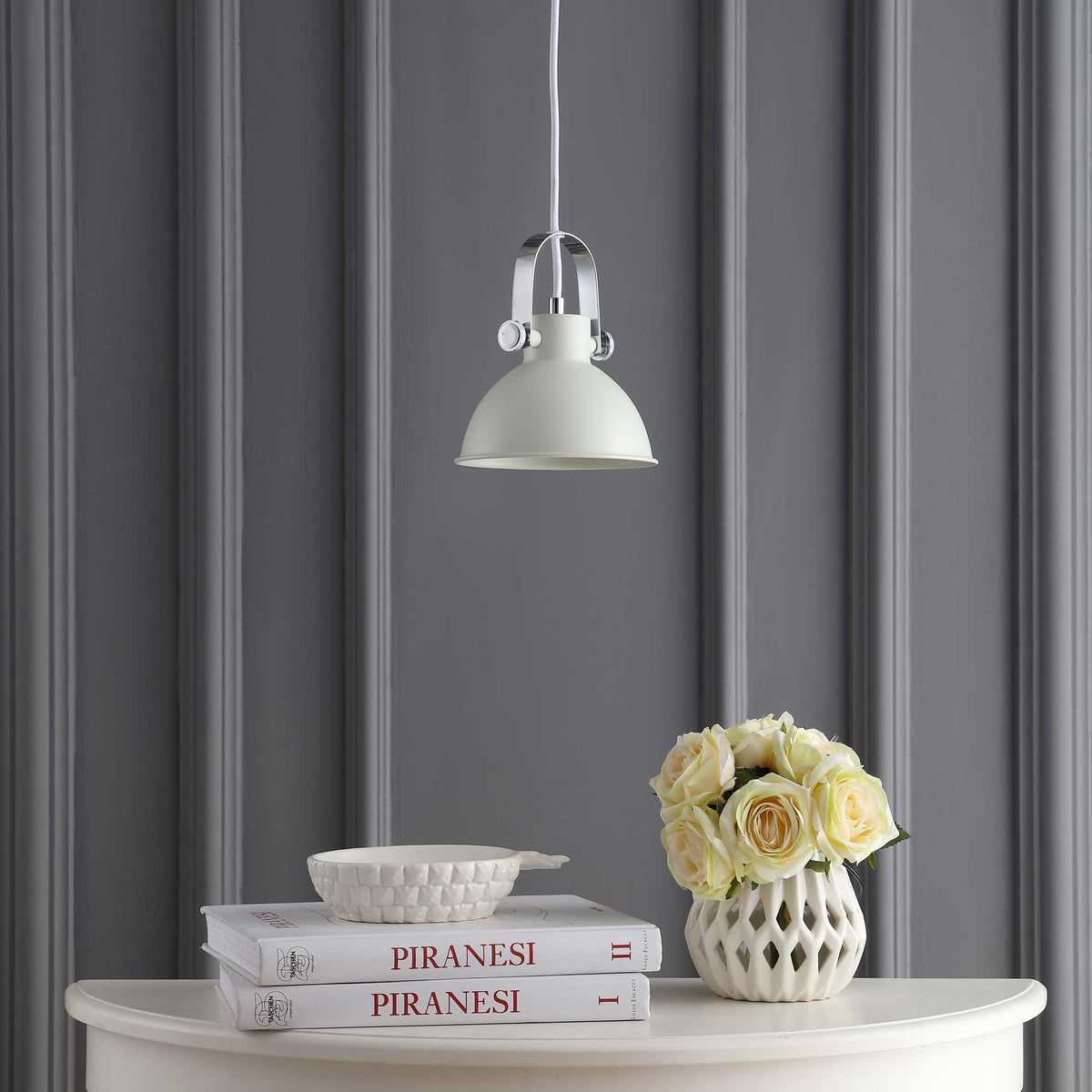 White dome pendant stands out against a charcoal paneled wall above a flower-adorned console