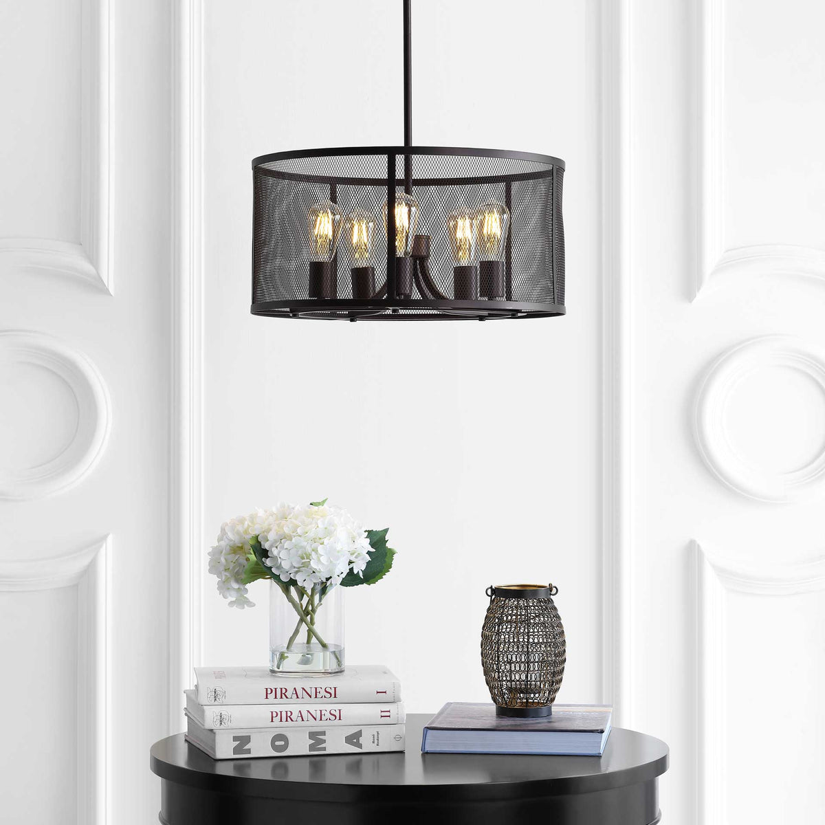 Warm amber light shines through the airy black mesh of this five-light pendant