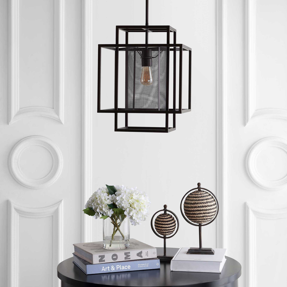 Geometric metal frames and a mesh shade add a sculptural accent above a round table