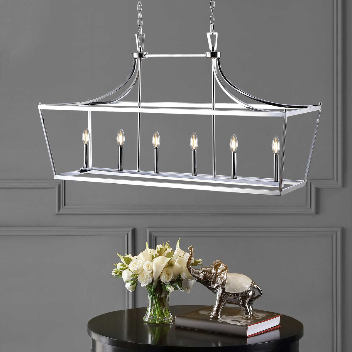 Warm light from six bulbs fills the gleaming chrome frame above a dark round table.