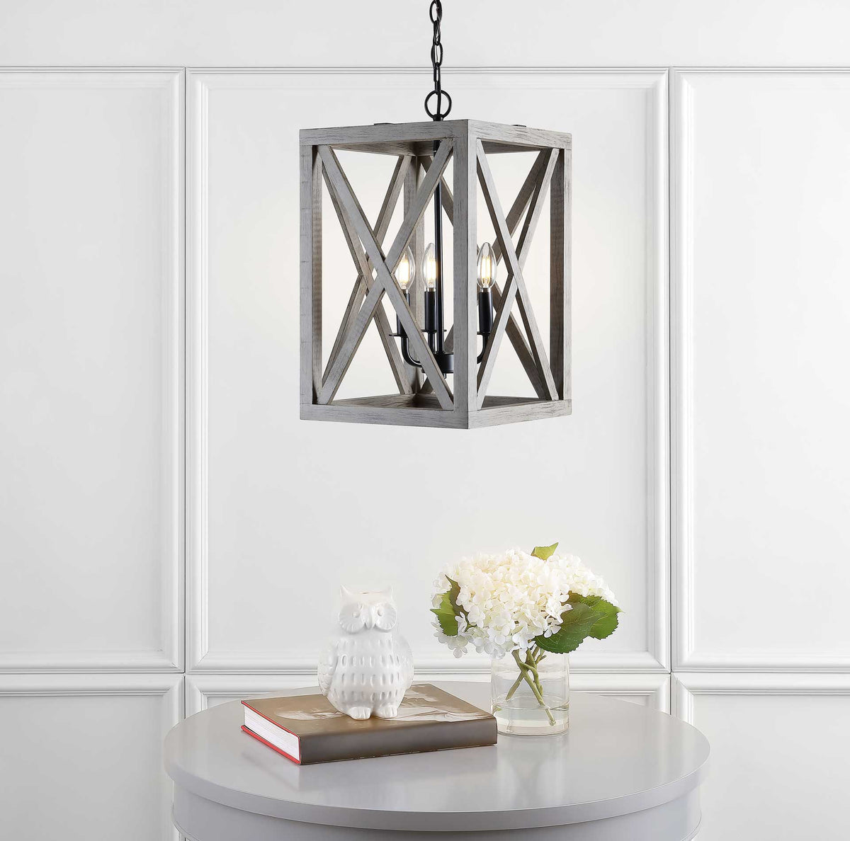Warm lights shine through the crossed wood slats of this lantern pendant