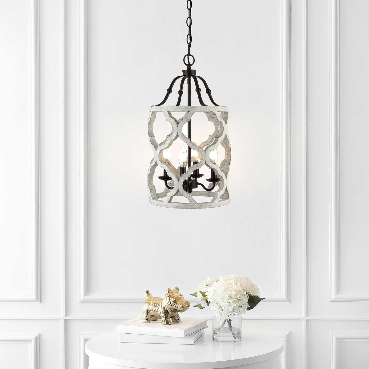 Warm candle lights glow within a curved white wood lattice above a white console table