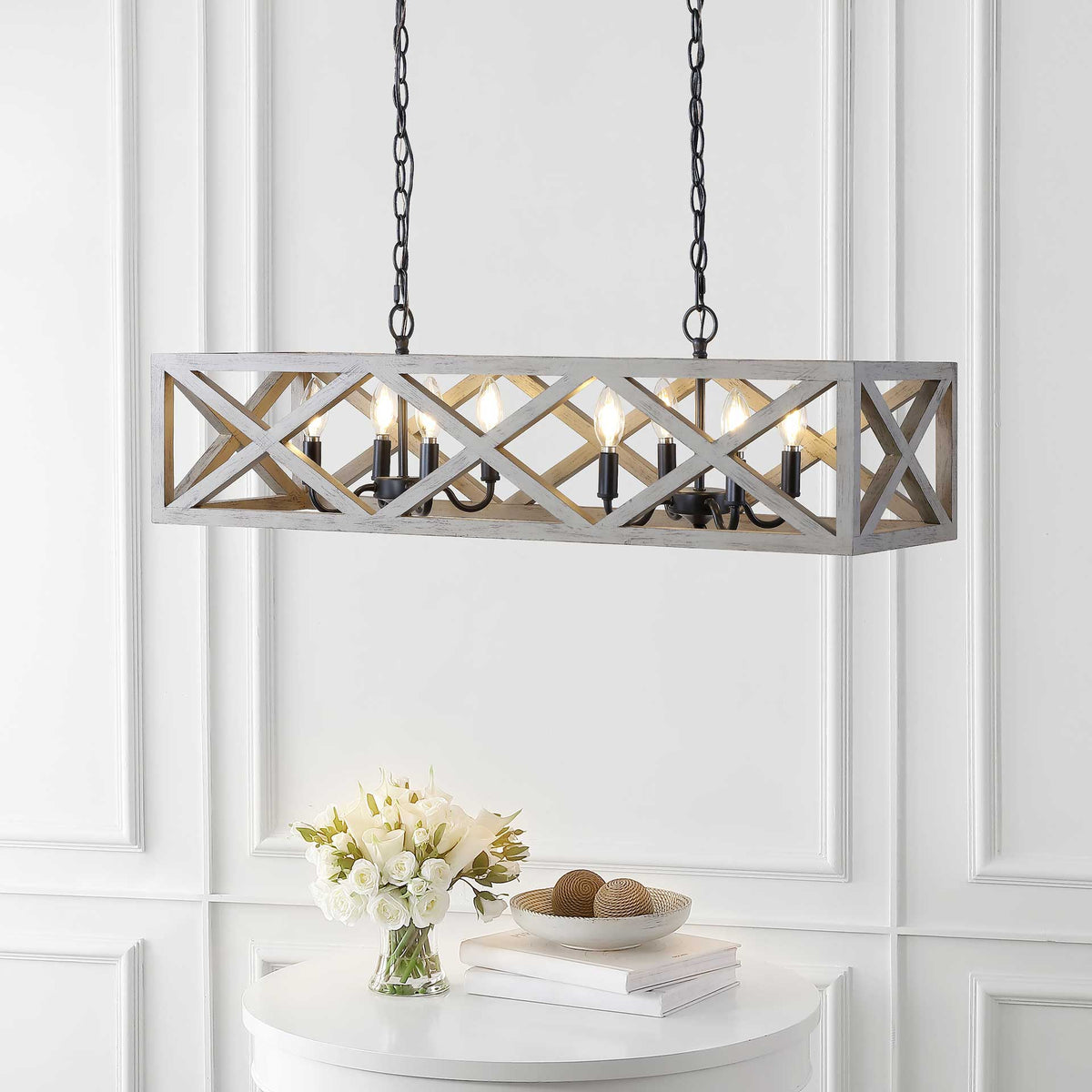 Warm candlelight shines through the open wood lattice above a round white table and flowers.
