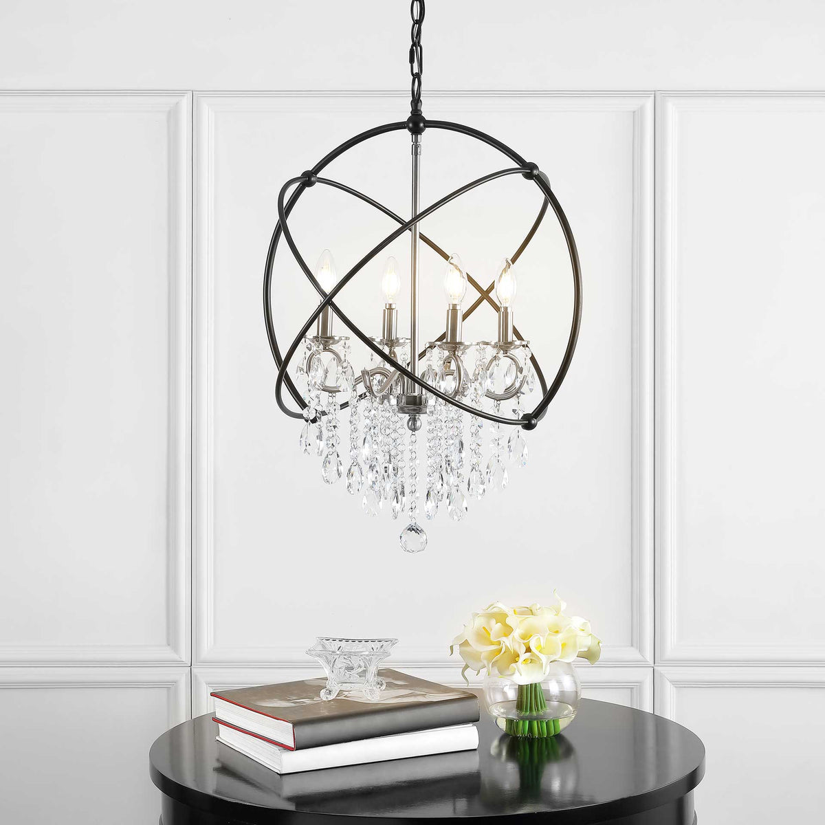 Warm candlelight glows through cascading crystals beneath sweeping black iron rings.