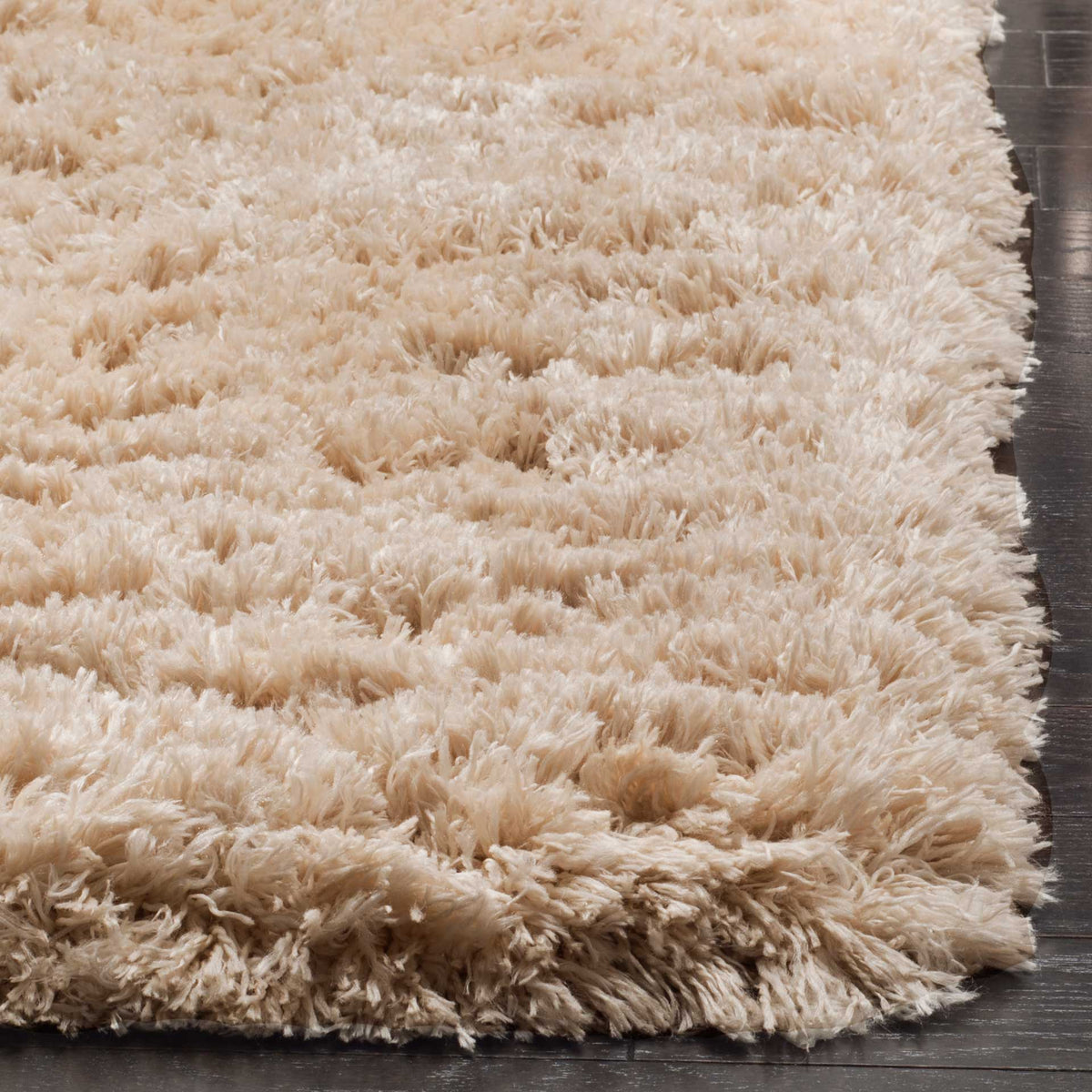A thick edge of light beige shag highlights the rug's long, densely tufted fibers.