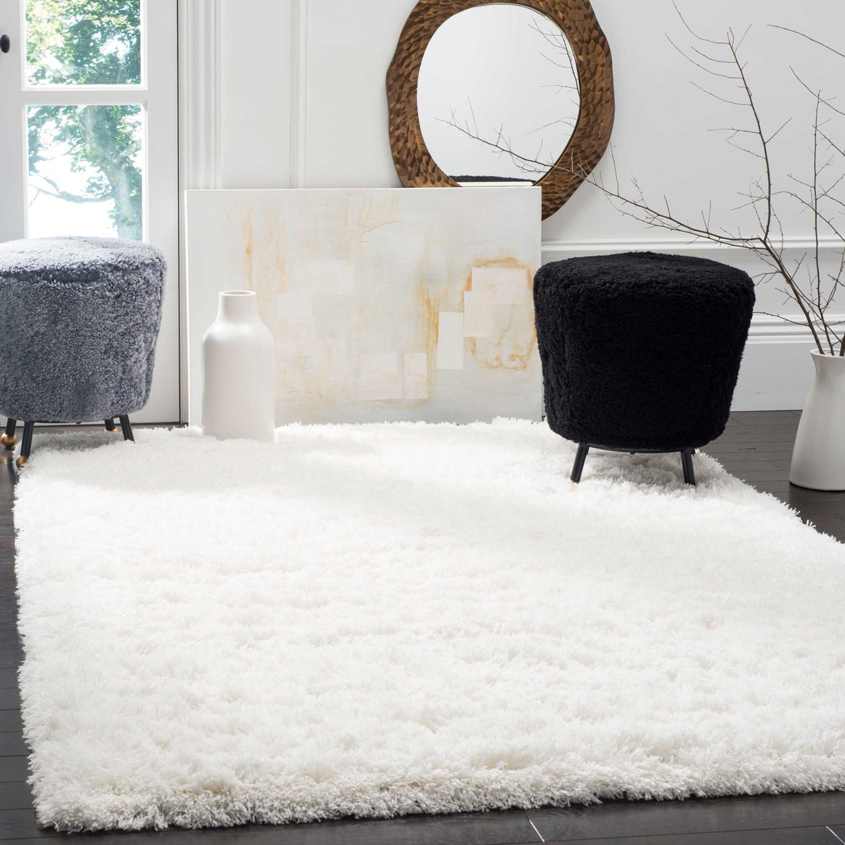 A white shag rug adds bright, plush texture beneath contrasting modern seating.
