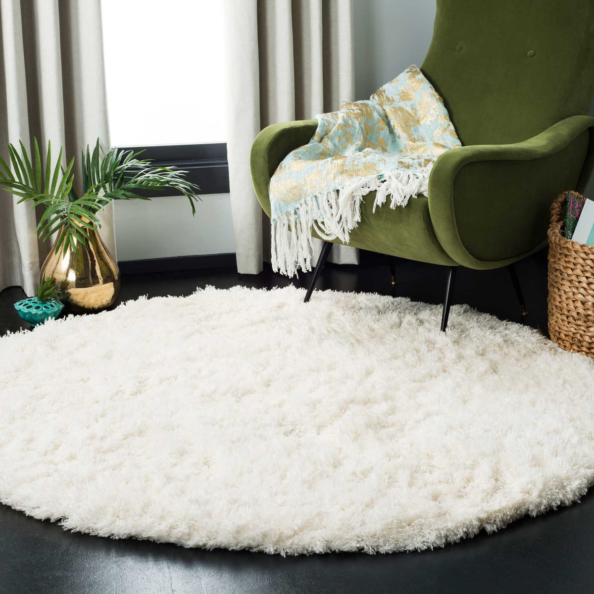 A plush white round rug lends soft, airy texture beneath a green accent chair