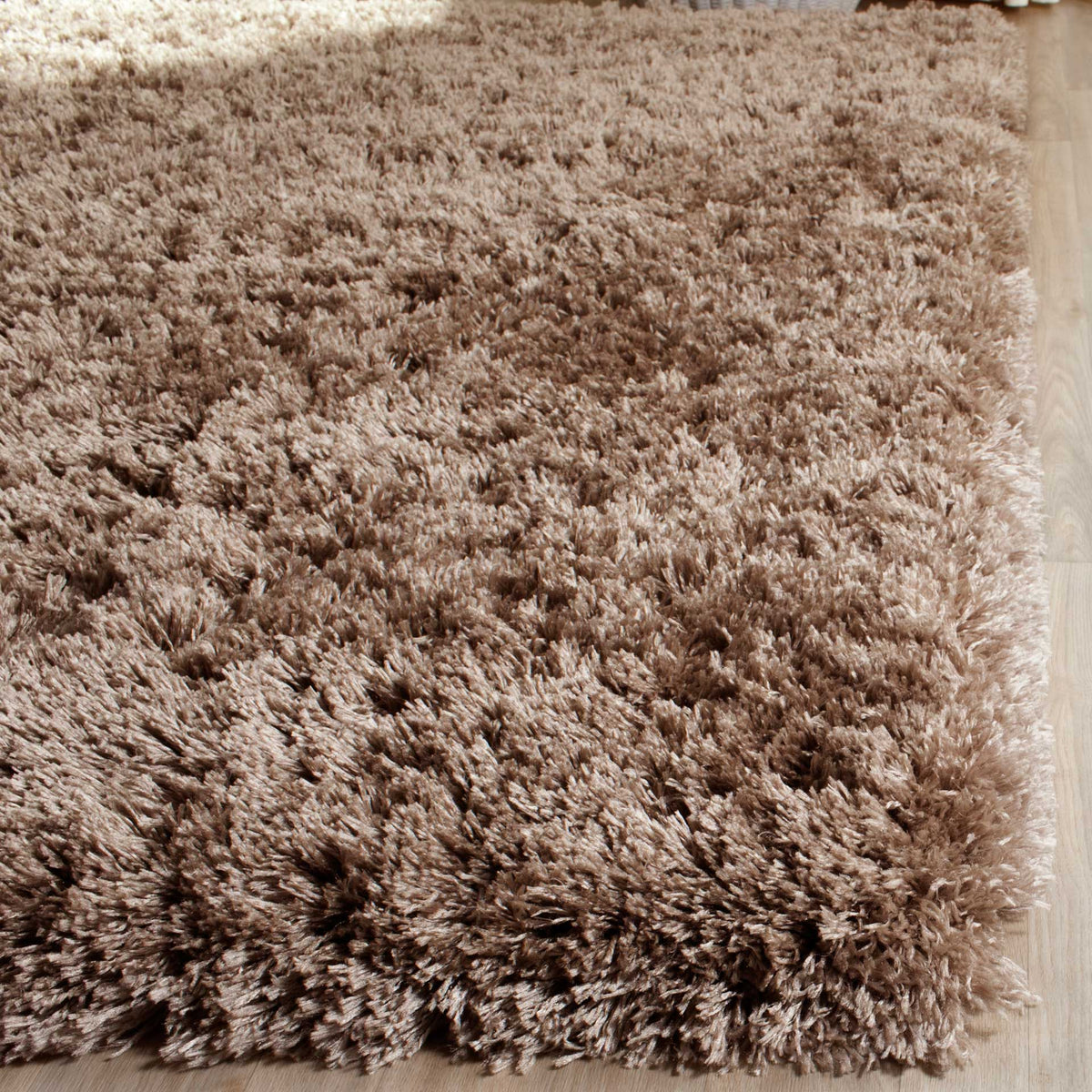 The thick edge of a mushroom shag rug shows its long, densely packed fibers.